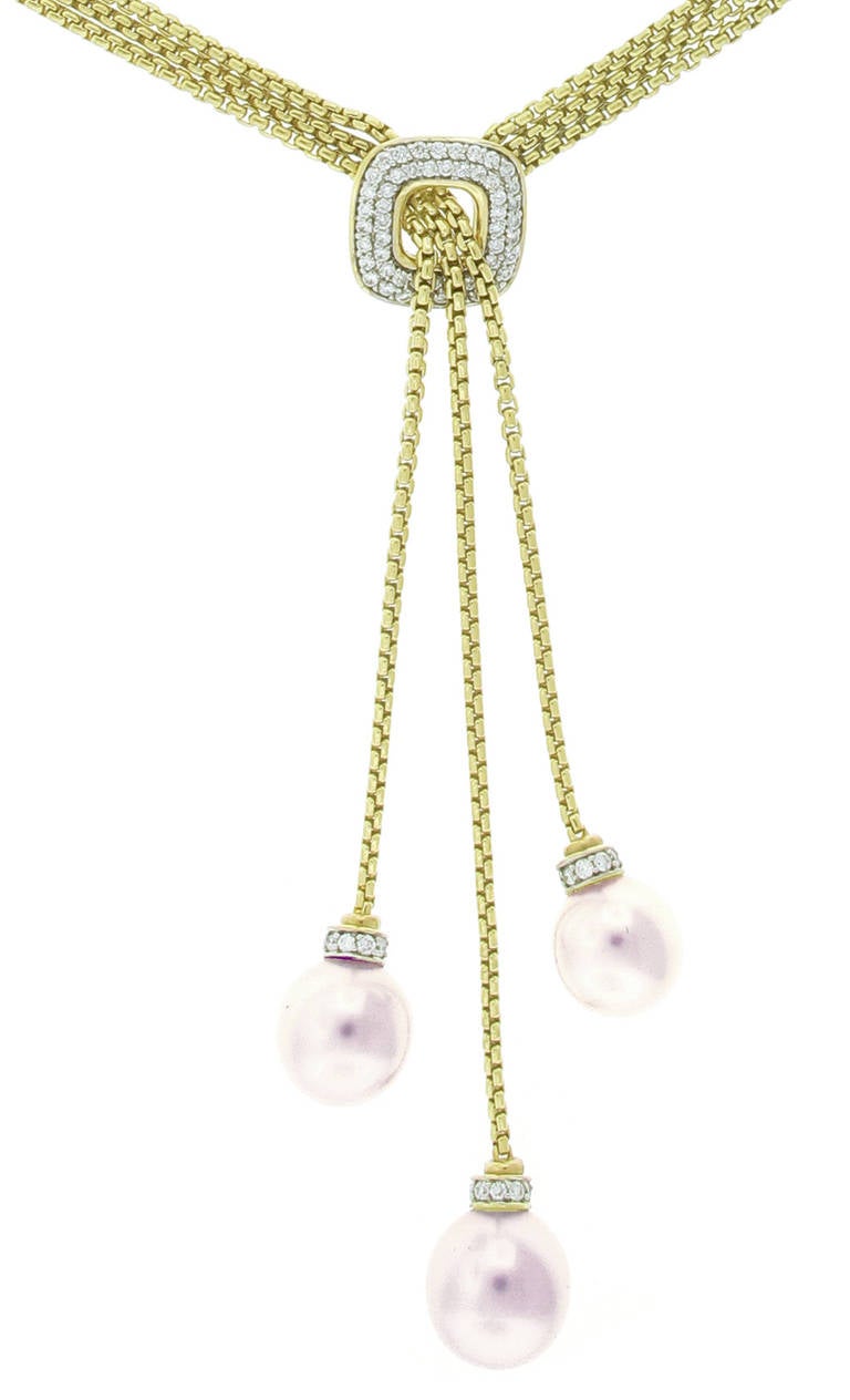 This David Yurman Gold, Diamond, and South Sea Pearl Necklace is in 18 karat yellow gold and contains 83 diamonds with a total weight of 1.66 carats in cushion shaped opening for the dandling south sea pearls. The lariat style necklace measures 19