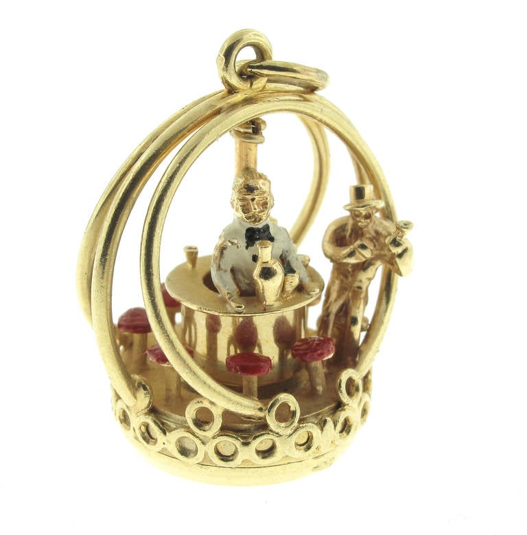 This Henry Danker Carousel Charm features a bartender ready to serve patrons, this charm actually winds up and the bar and bartender twirl around on their own. It is made of 14 karat yellow gold. The bartender and red bar stools are painted. The