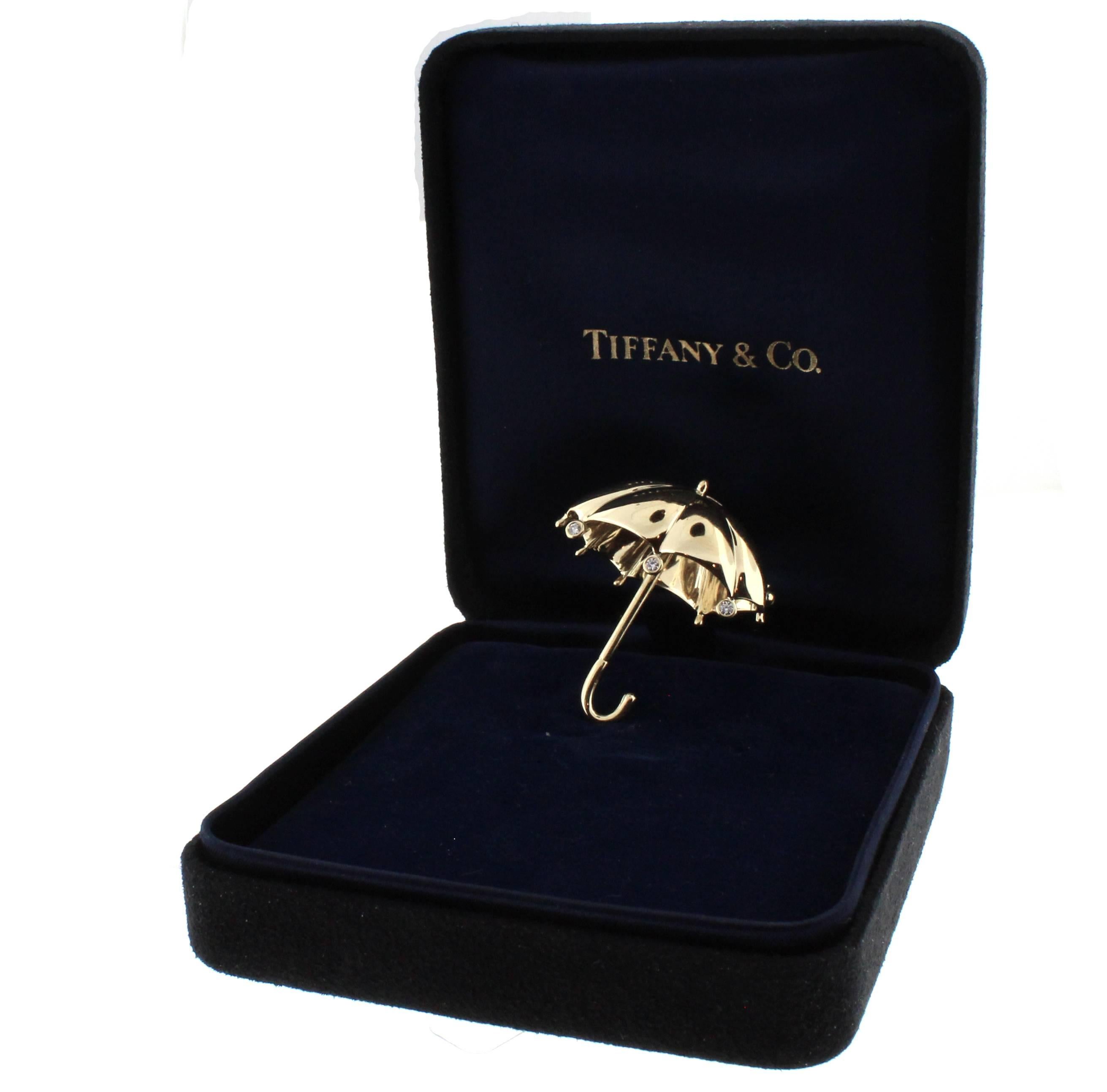 A whimsical umbrella brooch from Tiffany and Co. Set with three diamond rain drops this is the perfect accessory for a rainy day. This 18 karat brooch is in exceptional condition with no scratches or any signs of wear in it's original box.