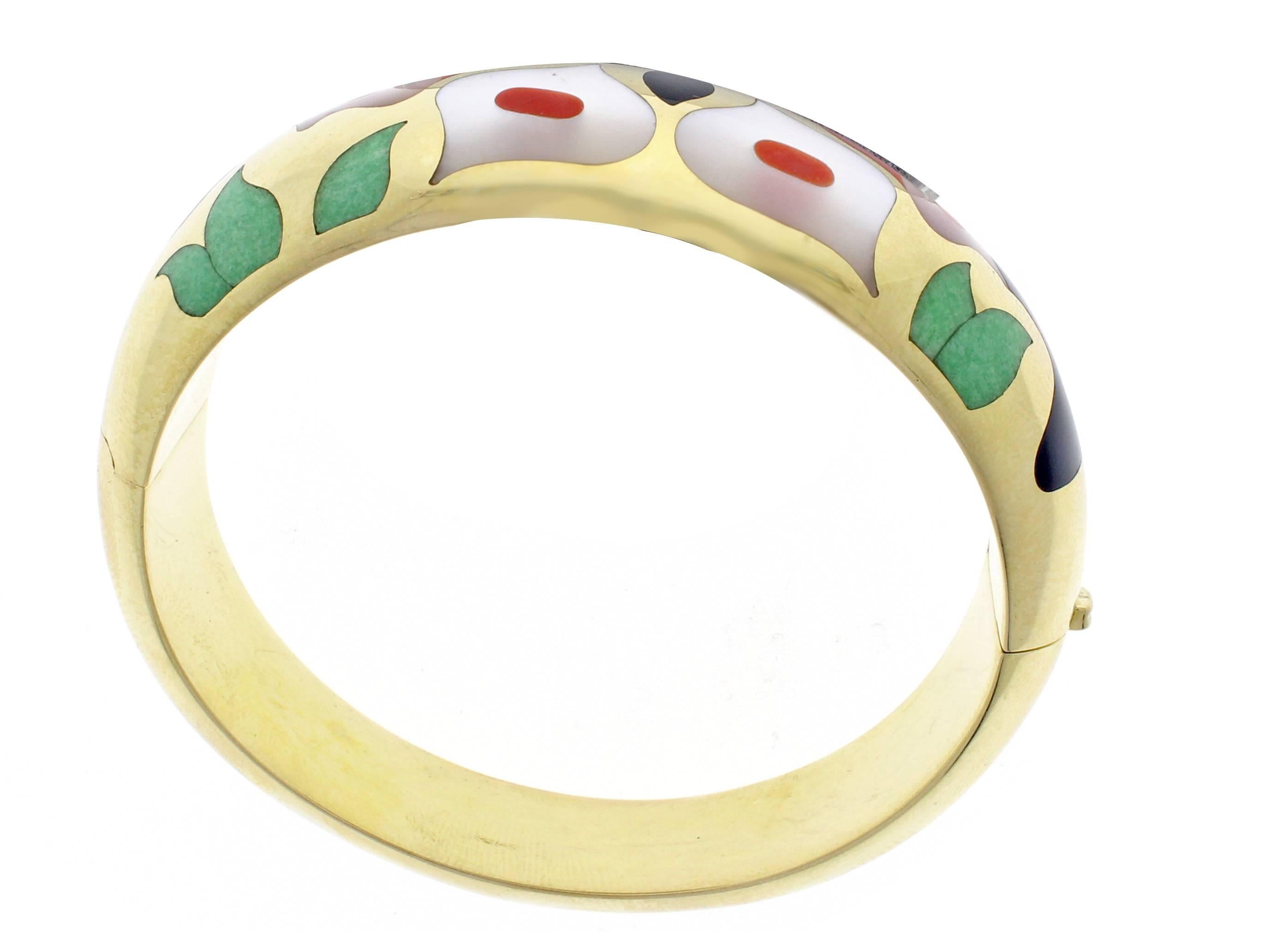 This Asch Grossbardt bracelet is circa 1990 and is 14 Karat yellow gold. The bangle features a beautiful design made out of hardstone. The bracelet measures just under one inch in width at the widest part and tapers to just over 1/2 an inch at the