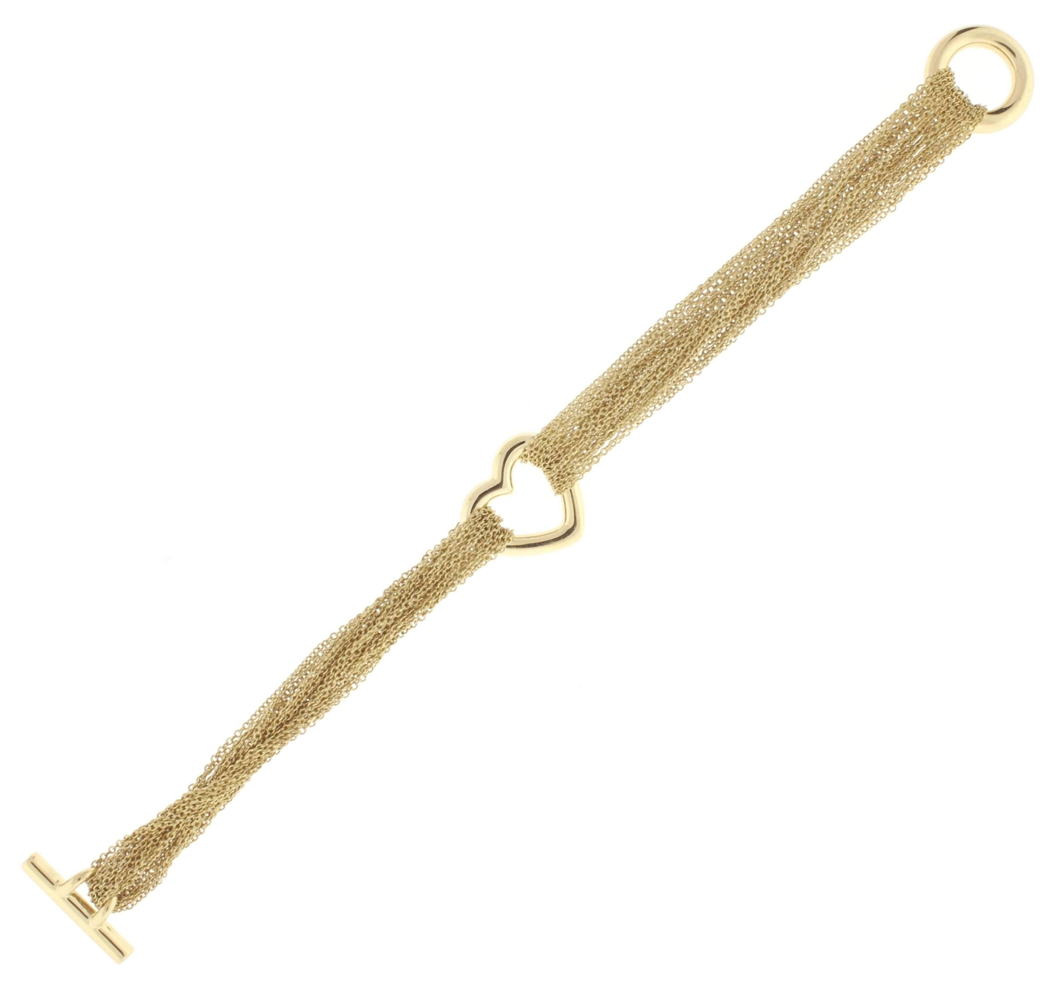 Crafted in18 karat gold from Tiffany and Co. This superb bracelet is comprised of multiple strands of chain with a center open heart and ring and toggle clasp.
6.5 inches 25.5 grams. 
