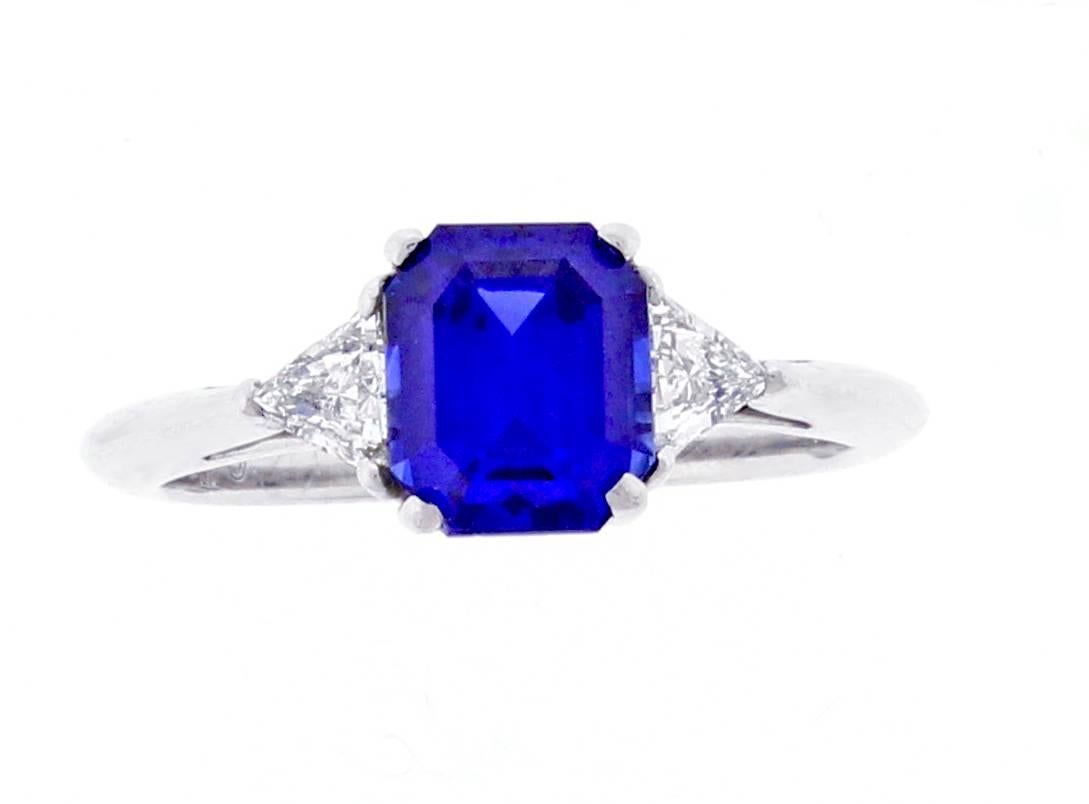 A stunning emerald cut sapphire is contrasted with brilliant trilliant cut  diamonds in this lovely ring from Tiffany & Co. The center sapphire weighs 1.78 carats with the two diamonds weighing .20 carats total. Signed Tiffany & Co. #22984543. size