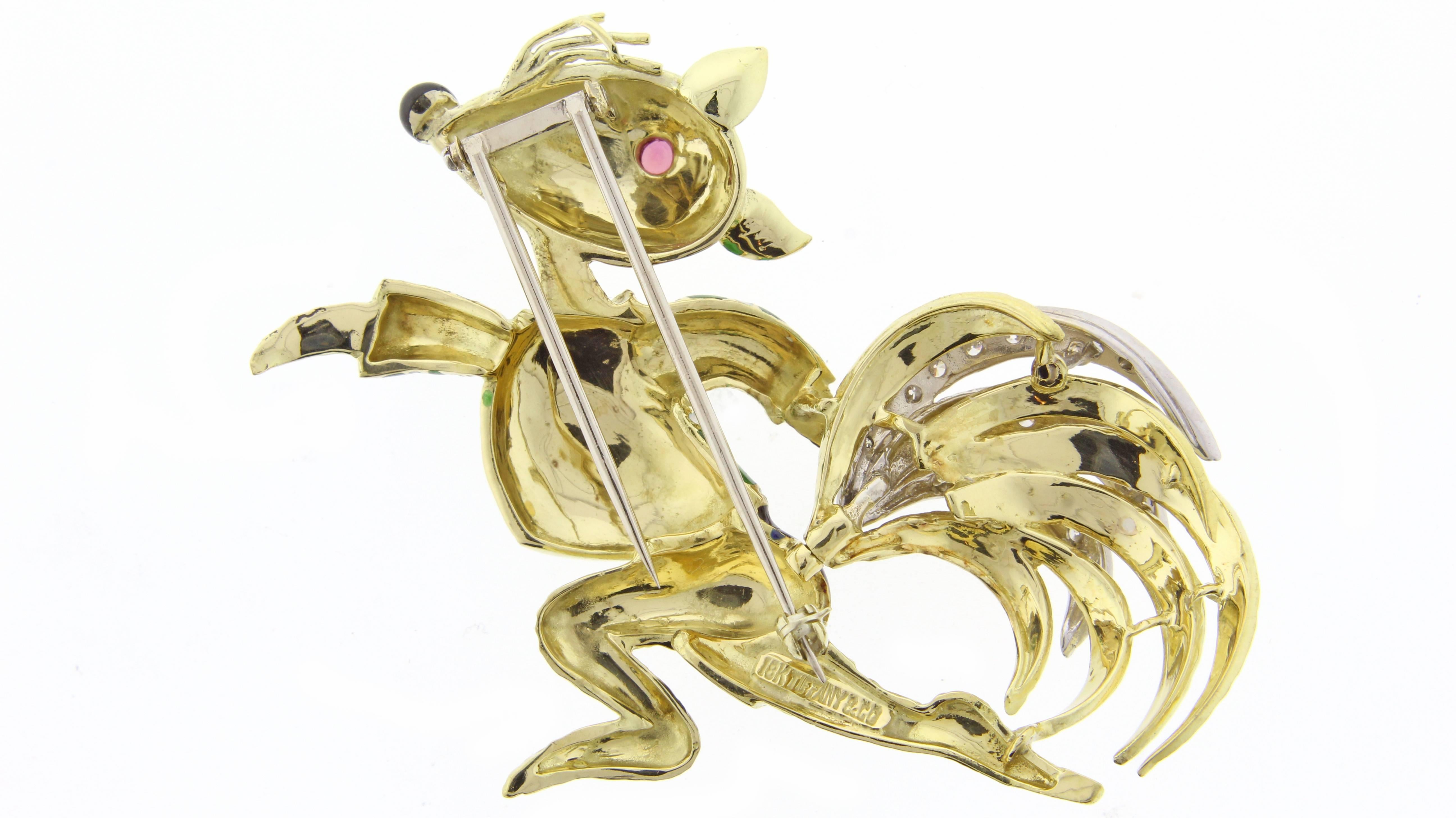 The  brooch depicts a sculpted 18k gold squirrel wearing a green and white guilloché enamel sweater and blue shorts. The tail is highlighted with over one carat of brilliant diamonds. Mounted in platinum and 18k gold, circa 1967, Designed by Donald