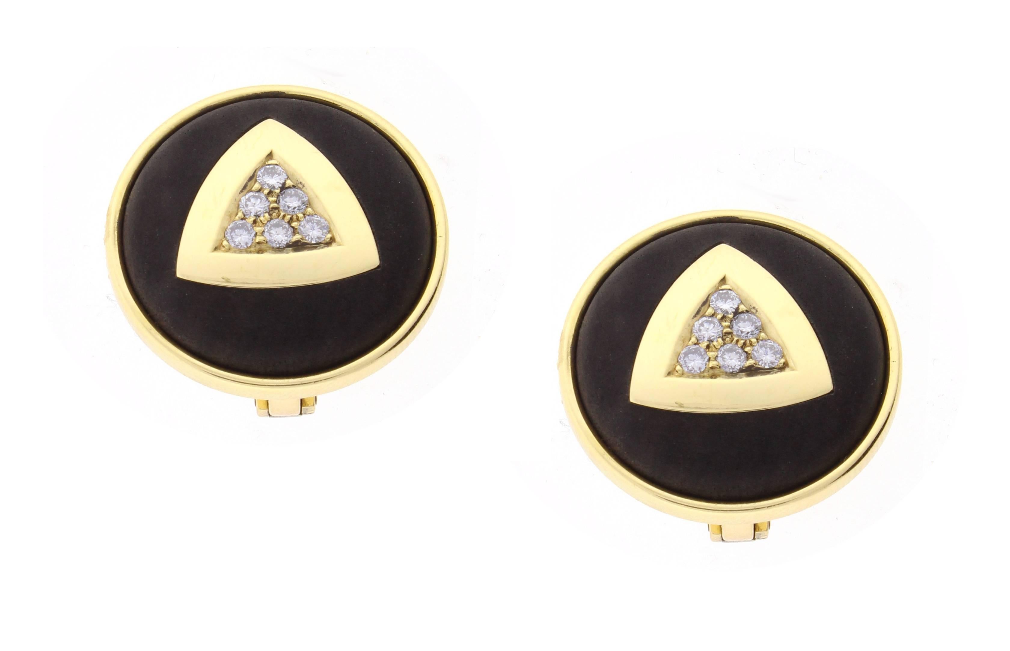 Leo De Vroomen is world renowned for his innovative and stunning designs. These lovely earrings feature a center triangle of diamonds inset in an ebony circle. The 18 karat gold earrings bear the official Assay Mark of London.  12 diamonds weigh