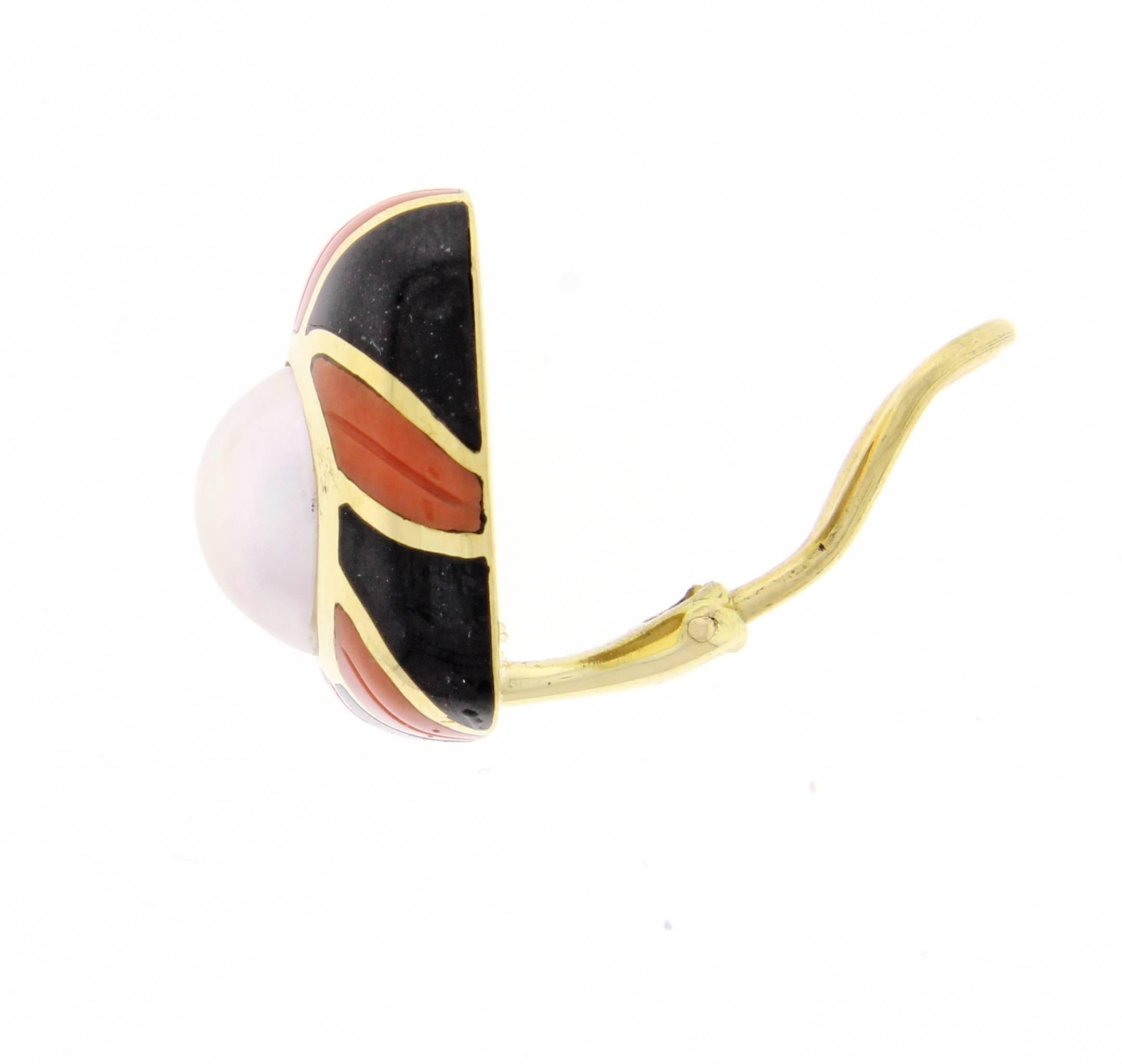 Rare 18 karat gold Tiffany & Co. Earrings. The earrings feature a 10mm mabé  pearl framed by a swirl of black onyx and carved coral.  3/4 of and inch square.