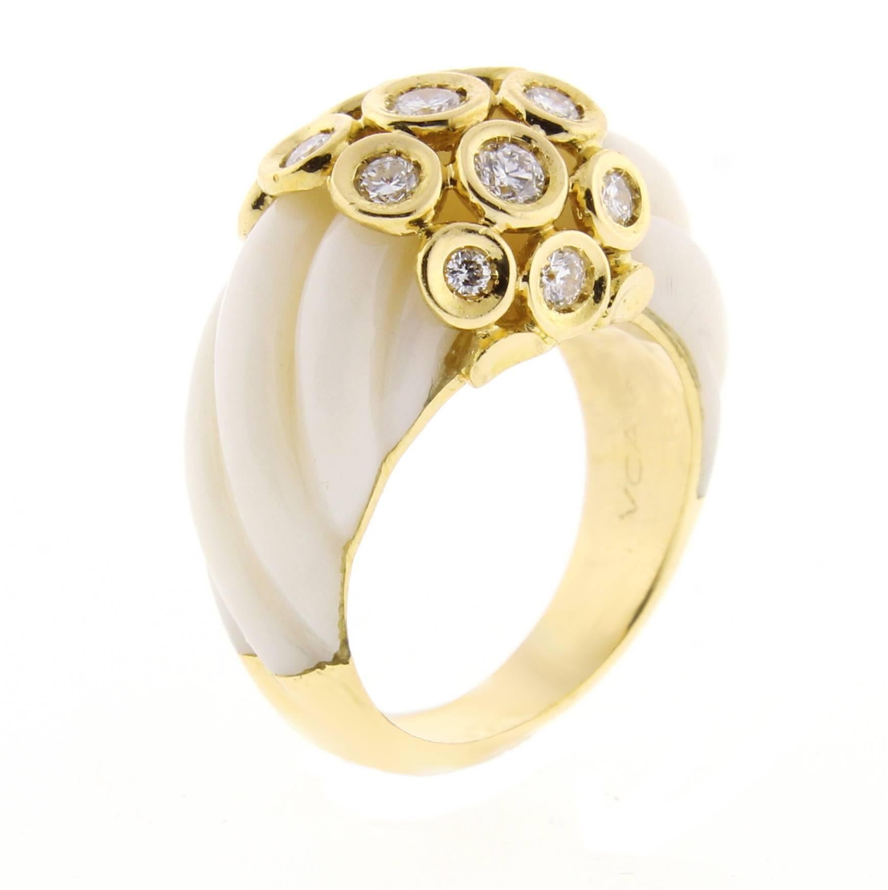 Wonderful 1970s Van Cleef & Arpels ring. This 18 karat yellow gold ring features 13 brilliant diamonds weighing .45 carats and two sections of carved  angle skin coral. The top of the ring is 1/2 inch wide. Size 5. 
