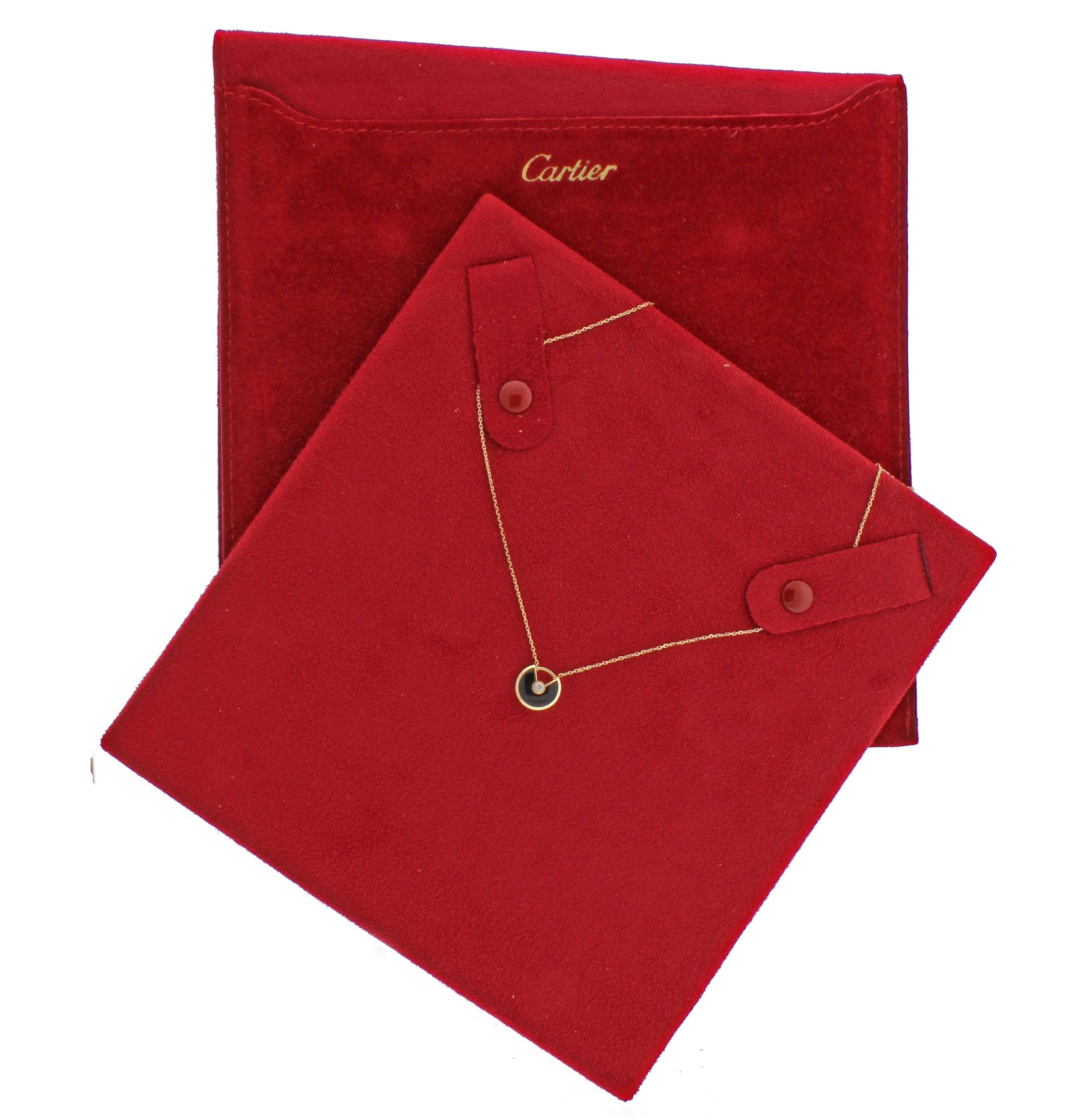 Amulette de Cartier, an enchanting collection of colorful lucky pieces symbolizing a myriad of wishes. Set in 18 karat pink gold holding an onyx and diamond pendant.  Brilliant diamond weighs .07 carats, Pendant 12mm  Necklace 16 inches 