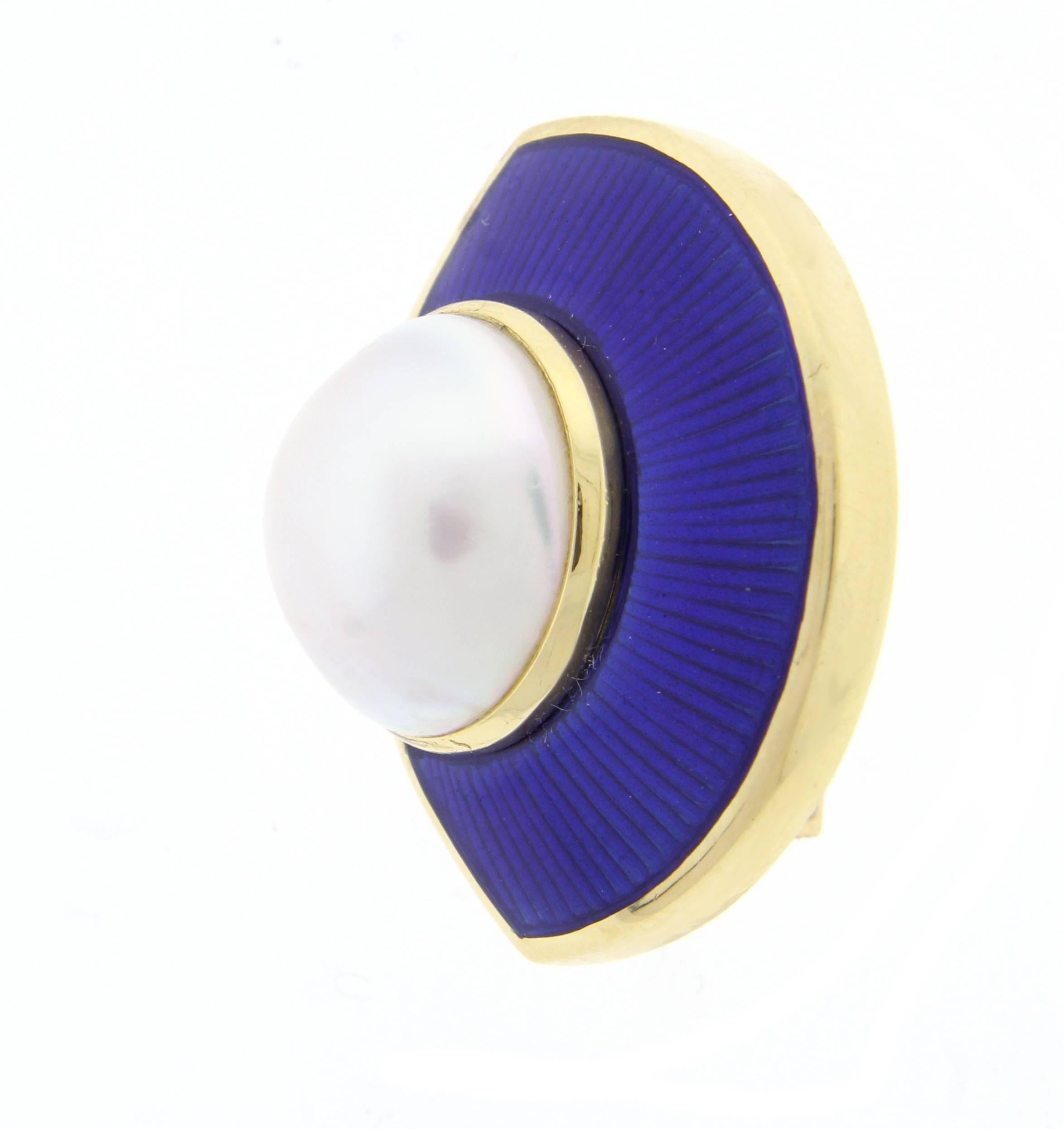  
Leo De Vroomen is world renowned for his vividly colored enameling and stunning designs. These lovely 18 karat gold earrings feature a 13mm mabé pearl. The pearl is partially framed by a fan of vivid blue French enamel.  The earrings feature