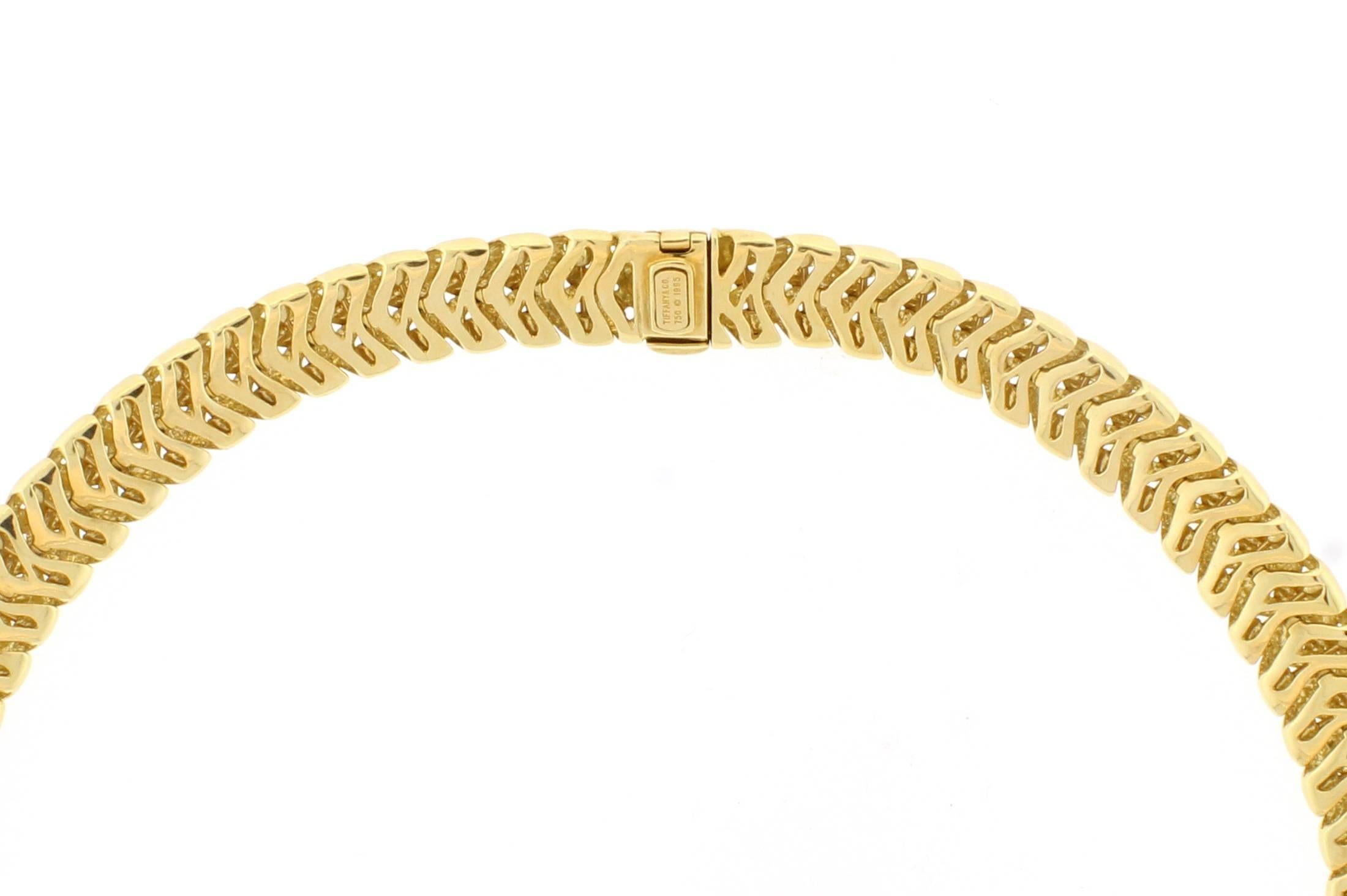 18 karat yellow gold and diamond “Vannerie” necklace by Tiffany & Co., dated 1995. The  necklace is comprised of  woven gold design measuring 1/2 inch wide, the front section is set with 2 diamond buckle sections, each containing 18  brilliant