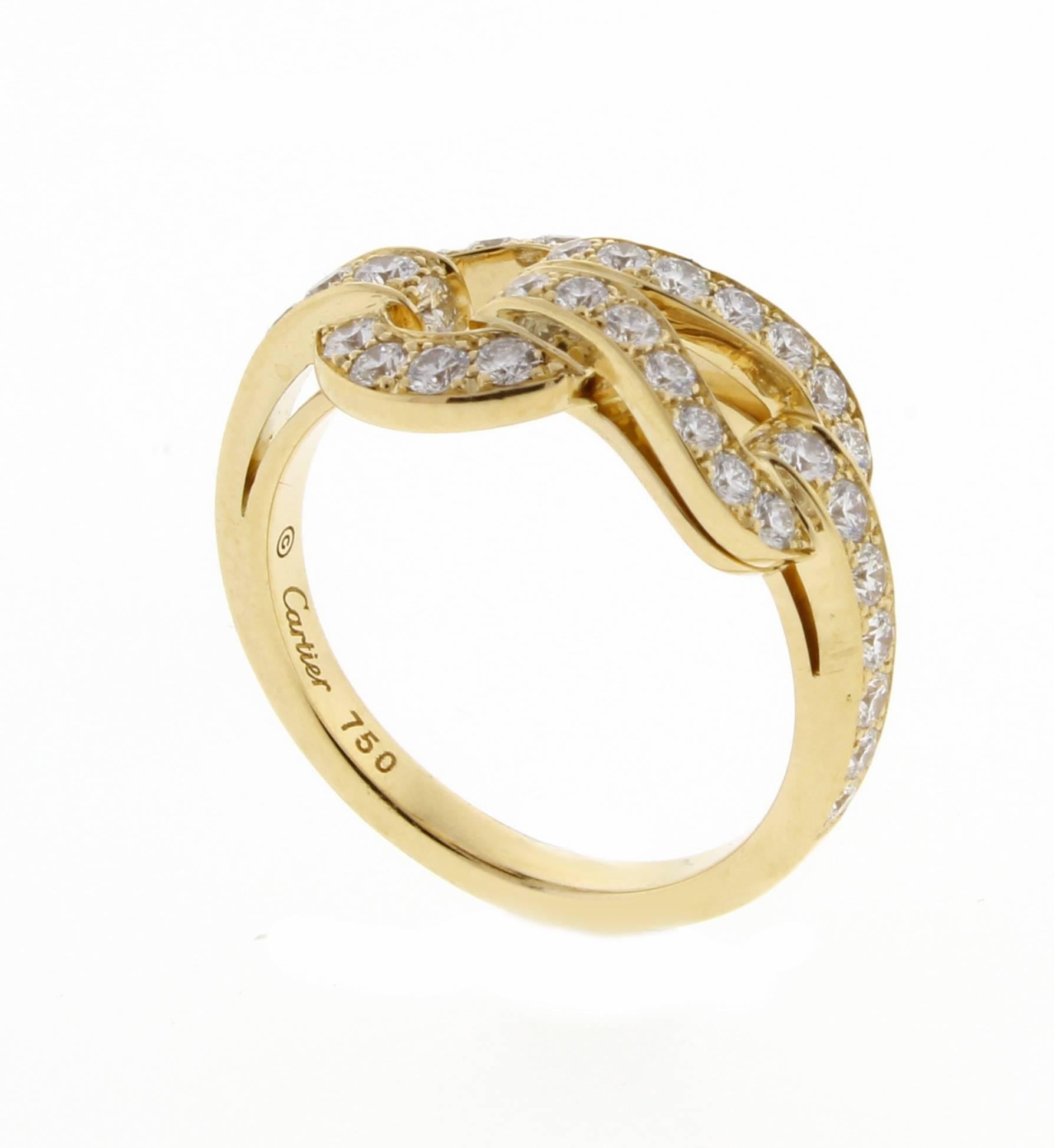 Cartier 18 karat yellow gold diamond Agrafe ring. Cartier borrowed the central motif for this jewelry collection from the world of fashion. Inspired by the clasps of the corsets this 18 karat yellow gold ring is refined and sophisticated. Set with