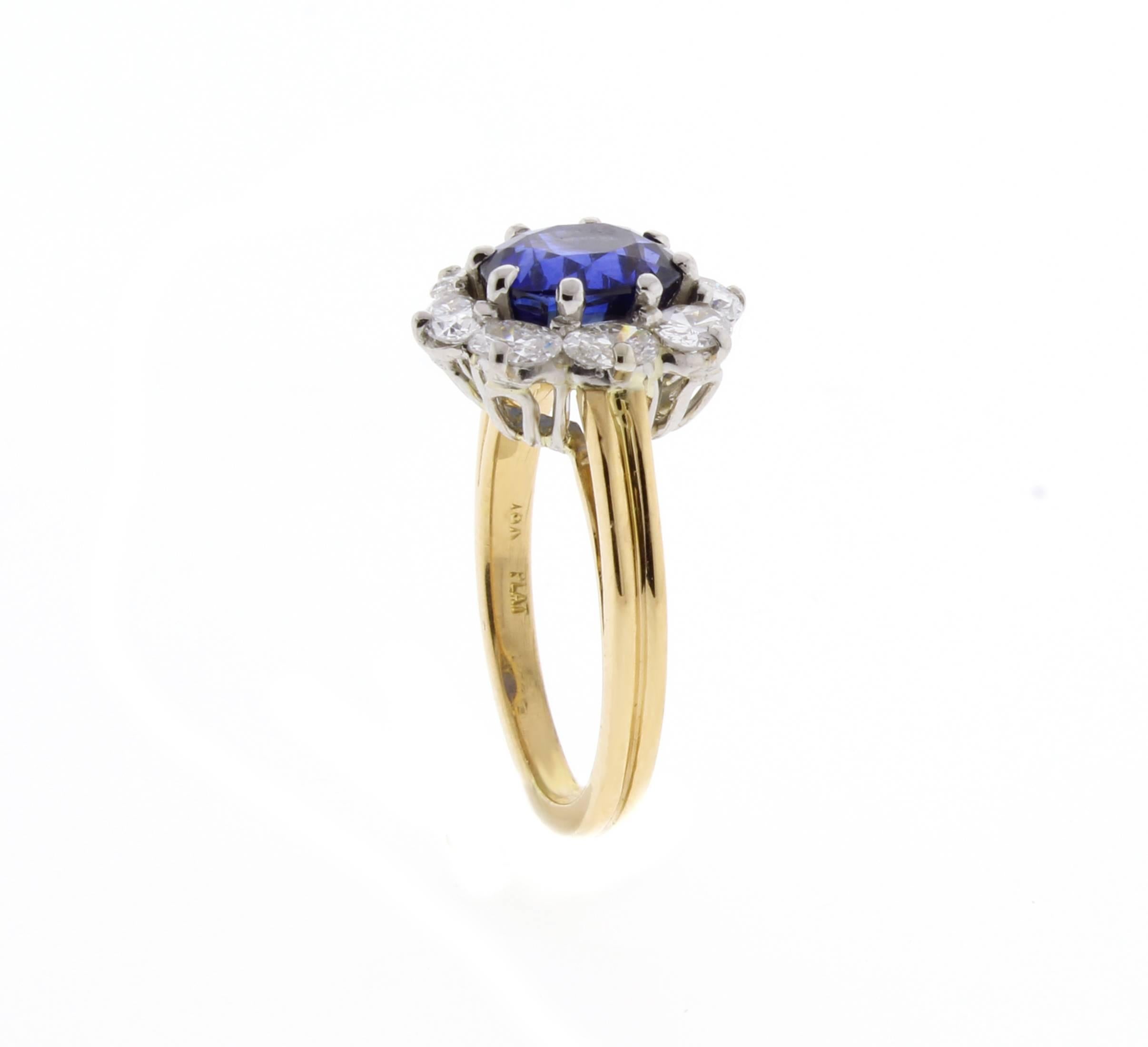 From the New York workrooms of Oscar Heyman, an oval diamond cluster ring. The center oval sapphires weighs 2.05 carats and is surrounded by 8 oval diamonds weighing  .80 carats. The diamonds are G color and VS1 clarity. Set in 18 karat and