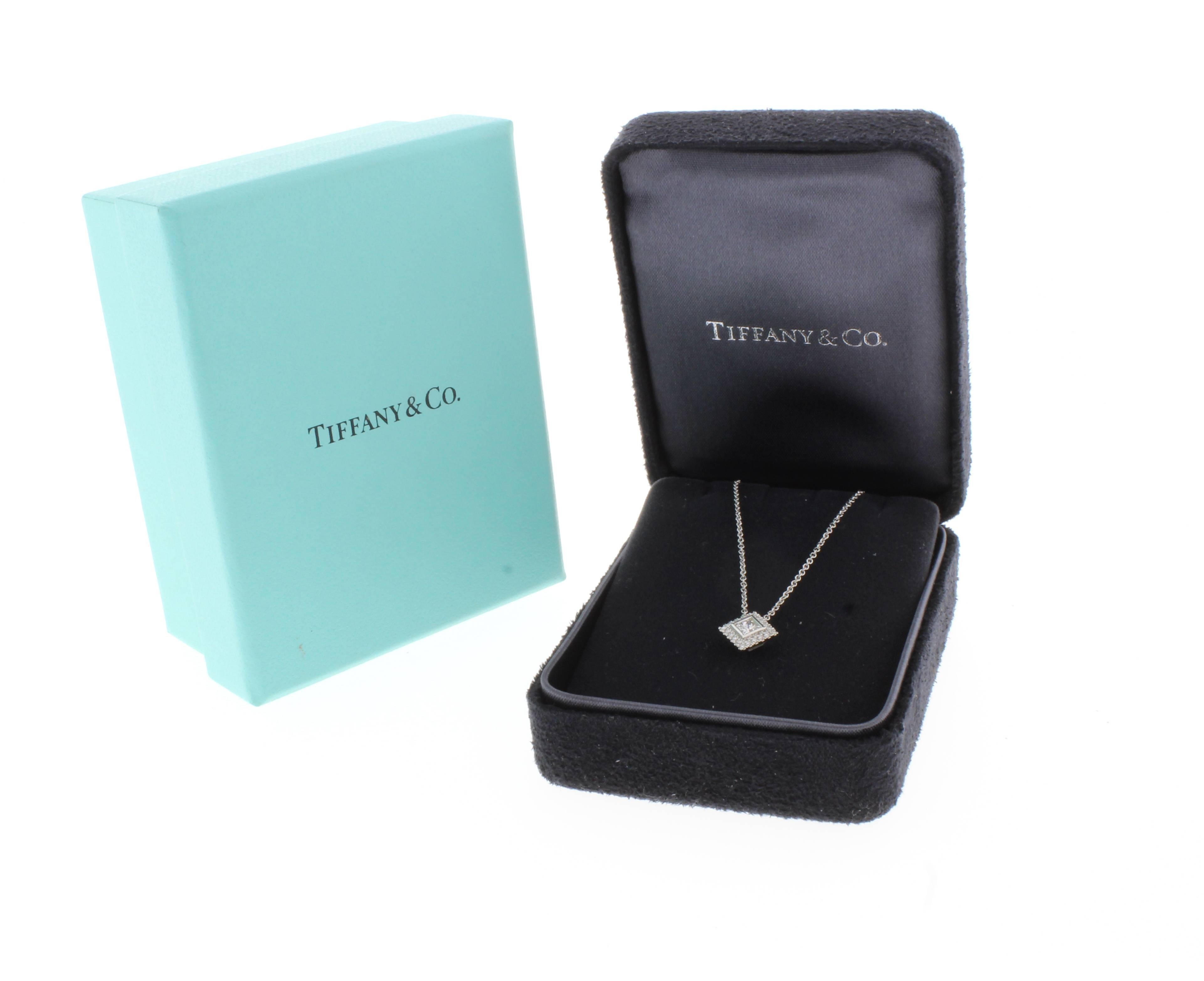 From Tiffany & Co's grace collection, a princess cut diamond pendant. The center square princess cut  and 20 brilliant diamonds weigh ..09 carats with the center diamond weighing .13 carats. The pendant measures 7mm square.  Set in platinum, 16