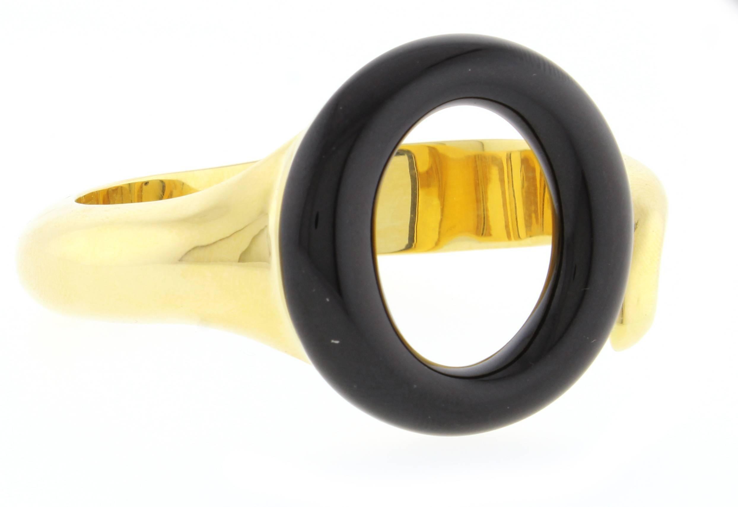 Peretti's elliptical form presents an intriguing figure.  The Sevillana black jade  18 karat gold bracelet by Elsa Peretti for Tiffany & Co. The jade measures 35 mm in diameter. The bracelet will fit up to a 6 1/2 inch wrist.  This bracelet has