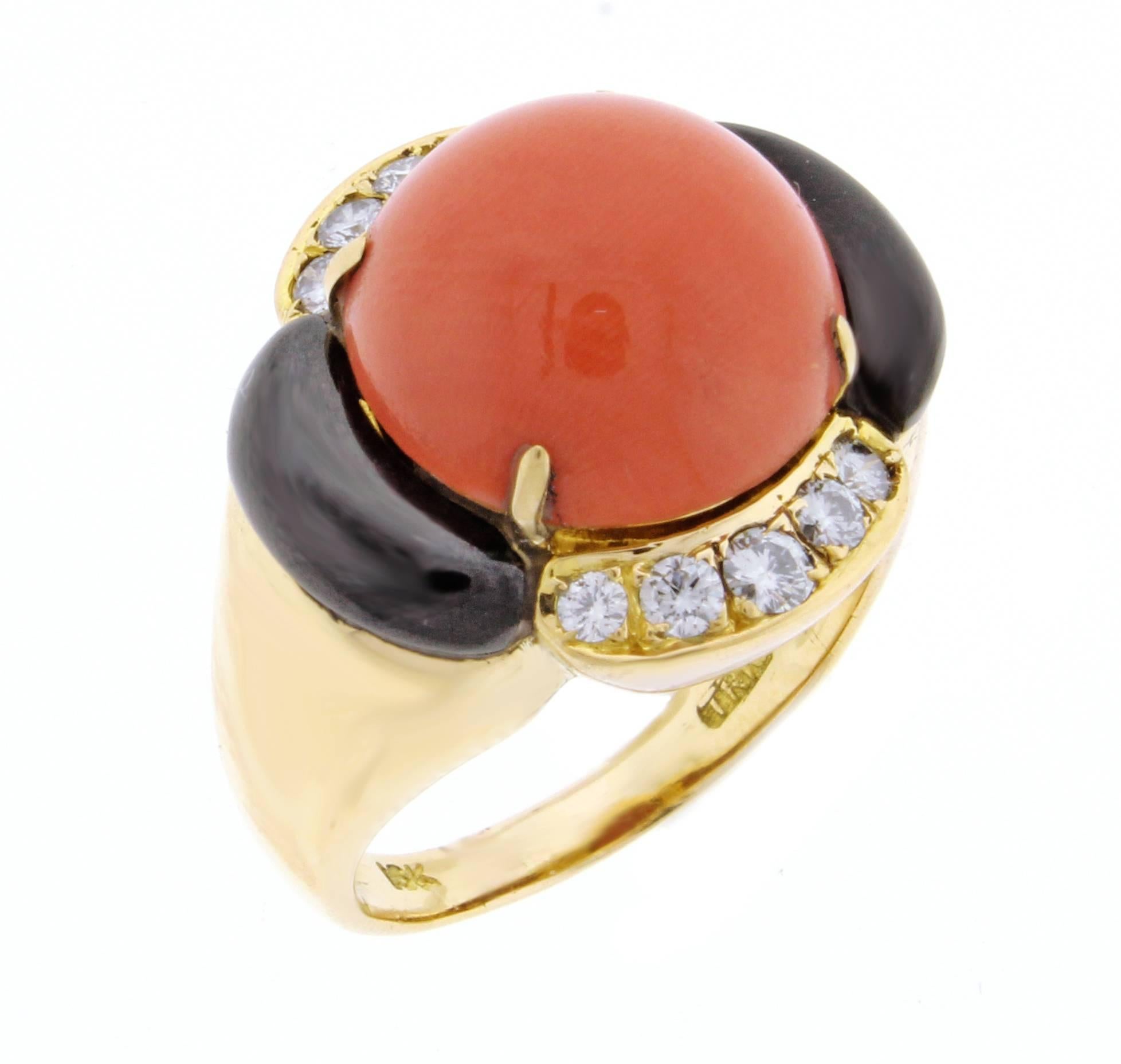 18 karat yellow gold salmon coral, onyx and diamond ring. The ring is comprised of a center 14 mm salmon coral cabochon and 10 brilliant diamonds weighing  .60 carats. Size 8  