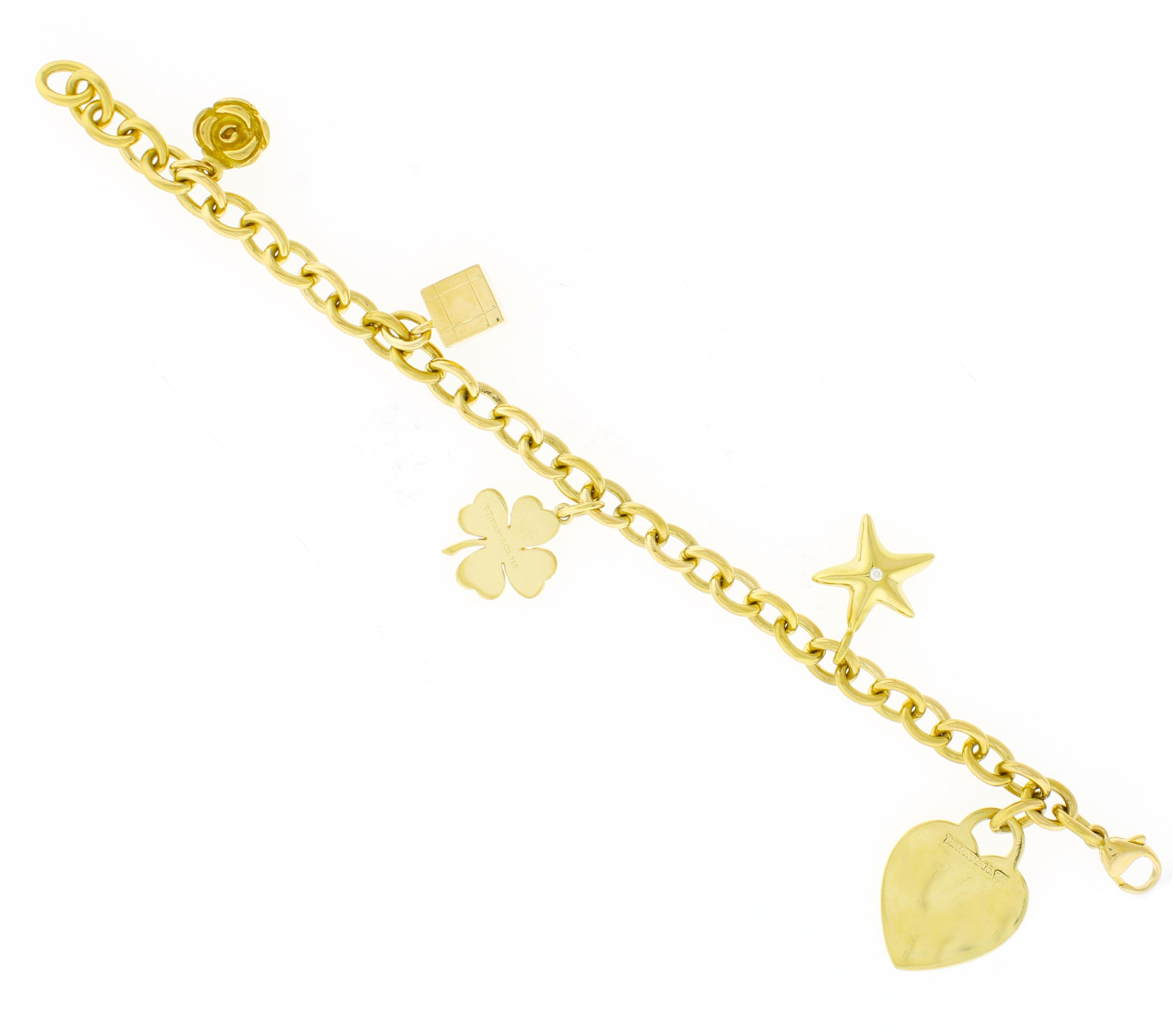 Esta exquisita pulsera Tiffany & Co. está fabricada en lujoso oro amarillo de 18 quilates y muestra la elegancia atemporal de Tiffany. Mide 7 ¼ pulgadas de largo y pesa  40 gramos, esta pulsera presenta una encantadora colección de icónicos charms