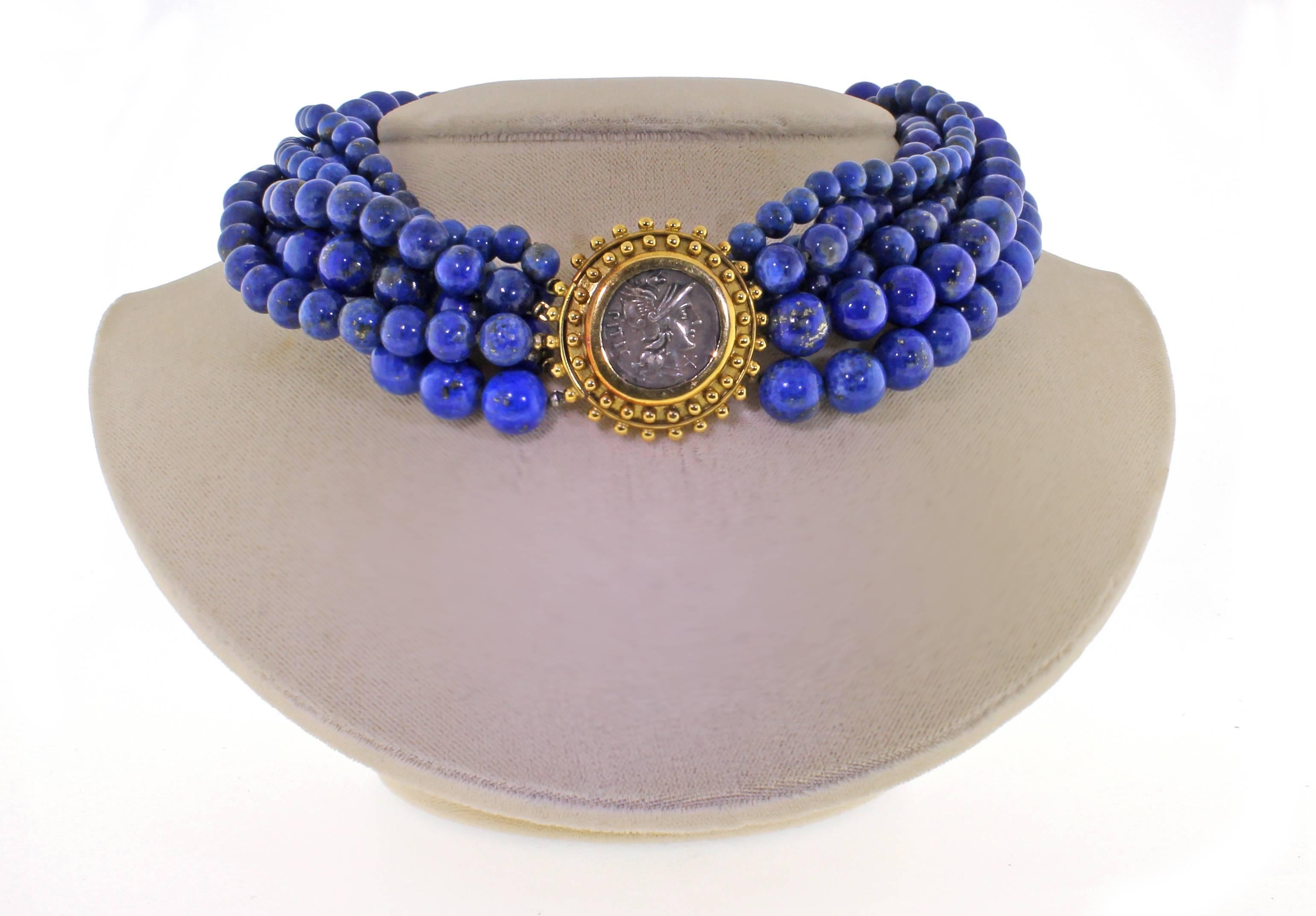 From Elizabeth Locke, a stylish  lapis bead and ancient coin necklace. The necklace features six stands of Lapis Lazuli varying in sizes from 6 to 10mm. The center 19 karat gold clasp measures 29 mm round and features an ancient silver coin. 16