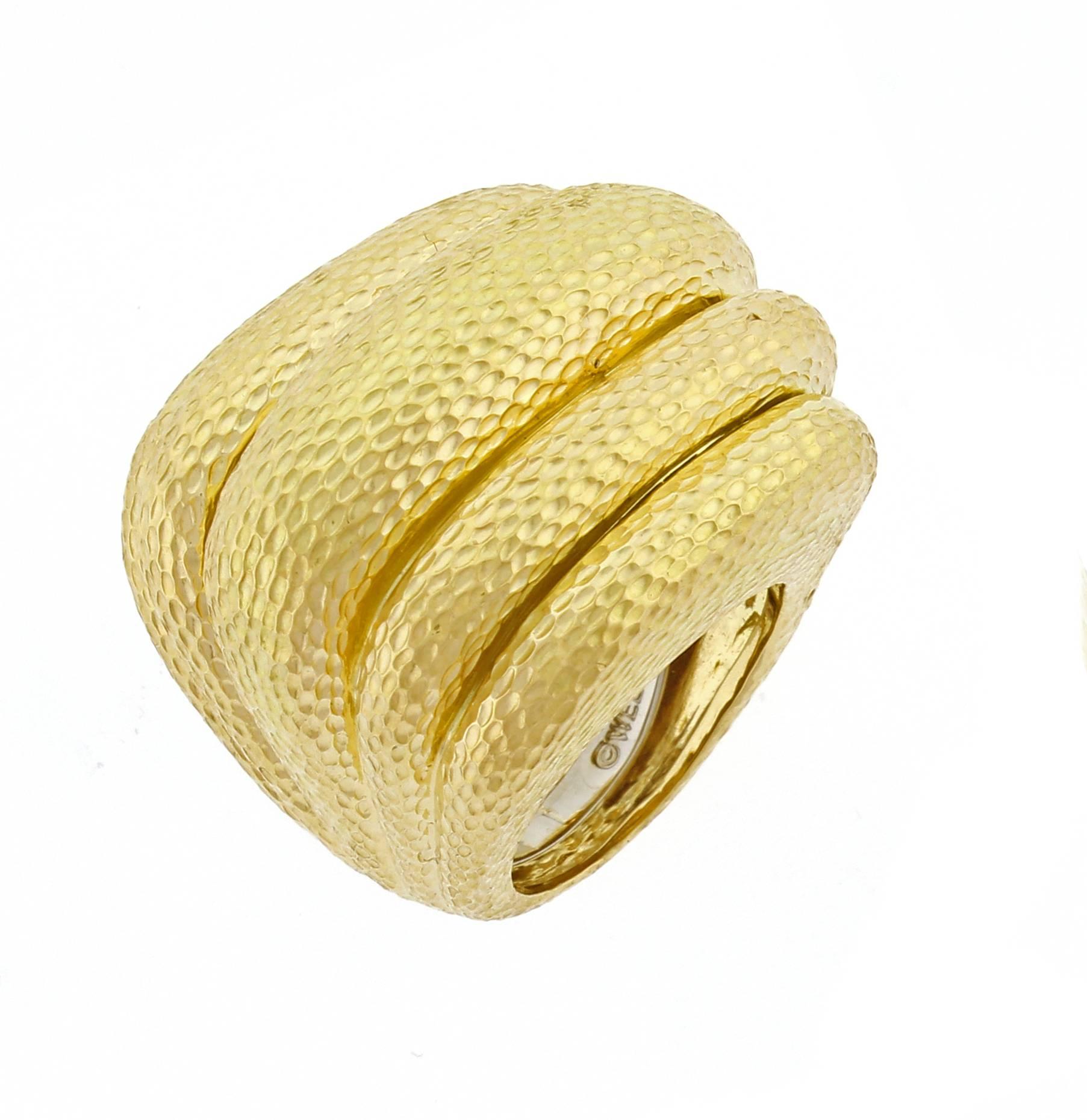 From David Webb, this fashionable 18 karat dome ring. The ring features David Webb's signature hand hammered finish and bold style. The ring measures 1.25 by 1 inch, 34.5 grams. Size 6 expandable guard. This ring has been restored to its original