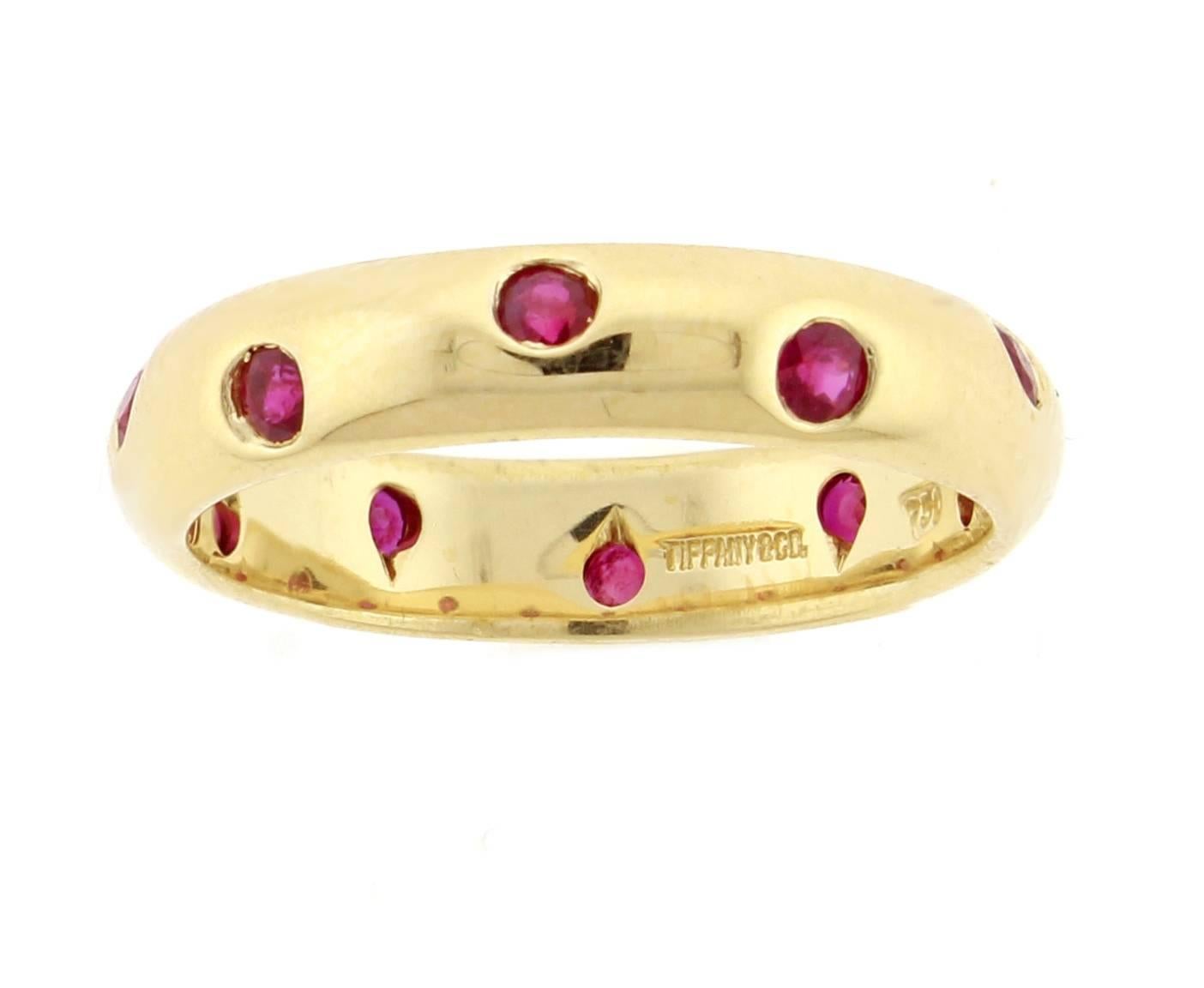 From Tiffany & Co. a ruby band ring from their Etoile collection. Set with 10 bezel set red rubies in a 4.3mm 18 karat yellow gold ring. Size 6.5