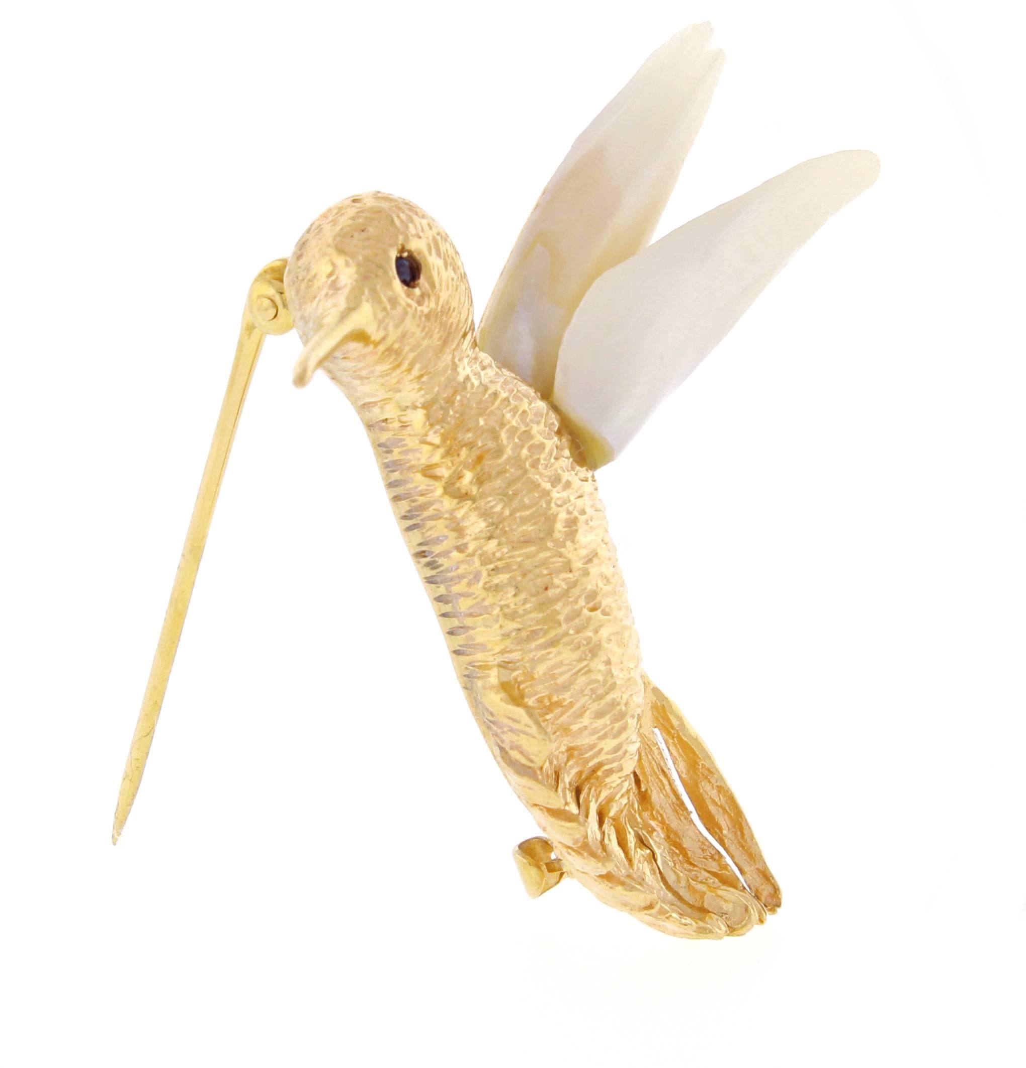  Whimsical hummingbird brooch by William Ruser is truly an special piece. A vintage design in textured and polished  14 karat yellow gold forms the figure of a hummingbird in flight.  Rare one inch elongated fresh water pearls form the wings.  1