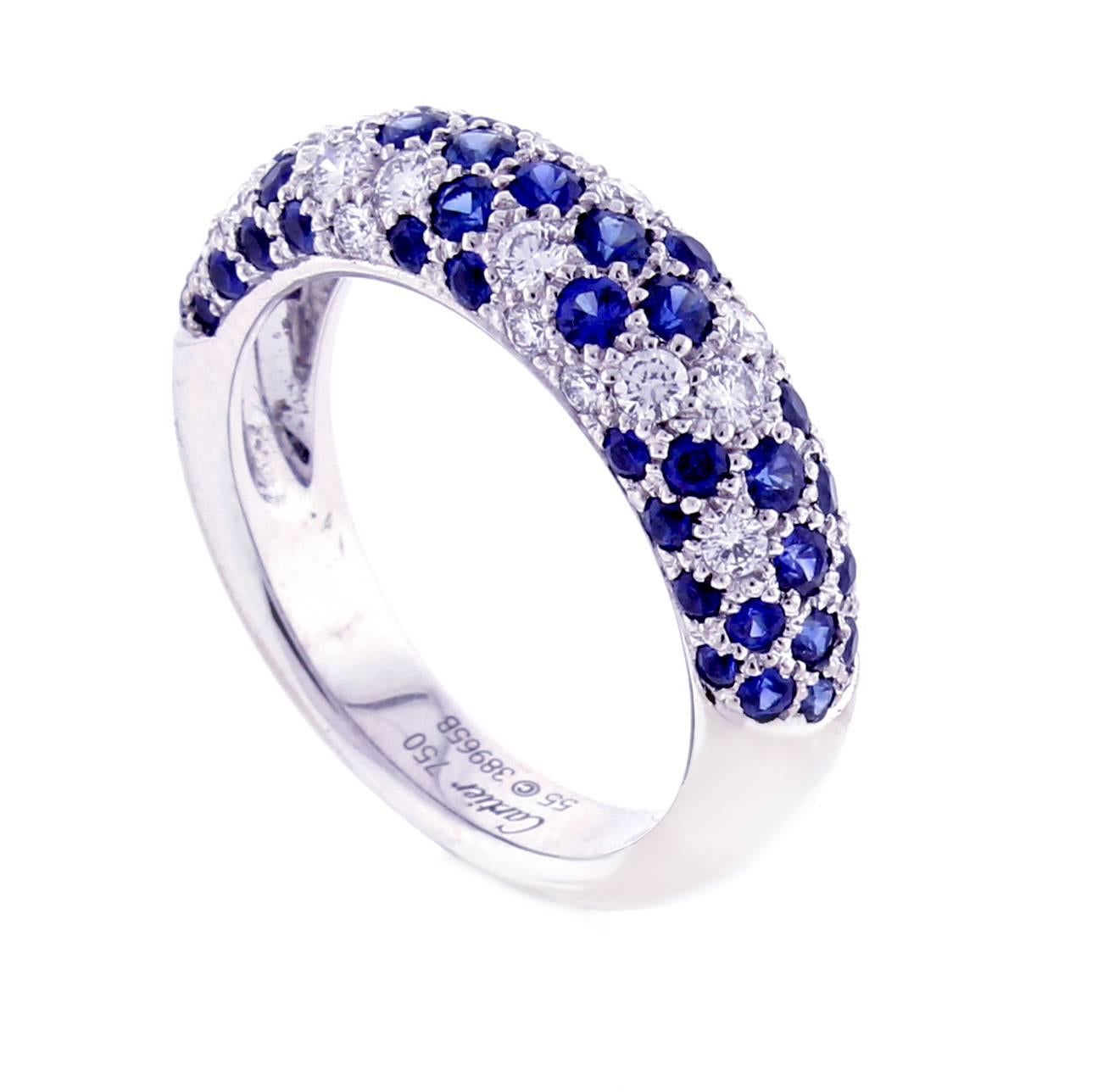 From Cartier, a vibrant sapphire and diamond 18 karat white band-ring. The ring is comprised of 50 blue round sapphires weighing approximately 2 carats and 19 brilliant cut diamonds weighing approximately .60 carats. The ring tappers from 6mm (¼