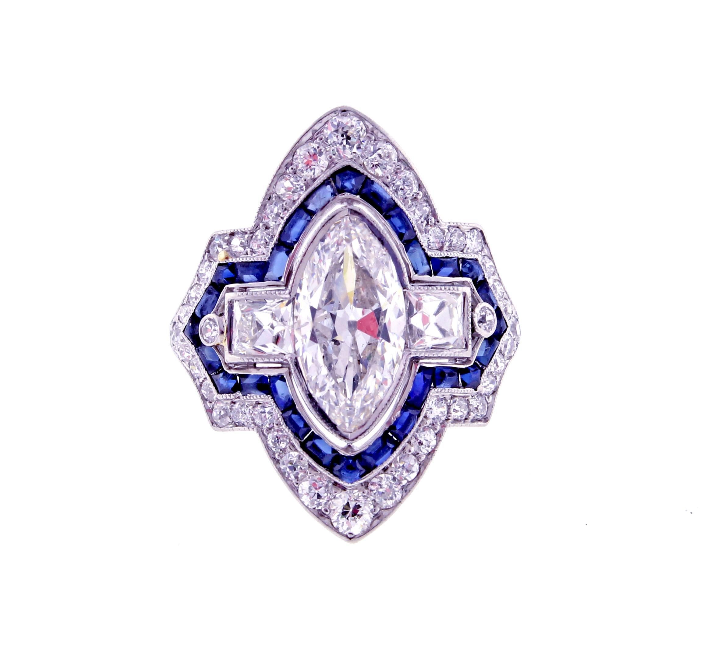 An exceptional example of Art Deco design and hand craftsmanship. The platinum ring is comprised of a center marquise diamond surrounded by sapphires. The center marquise diamond weighs approximately 1.50 carats. The diamond is E color and SI