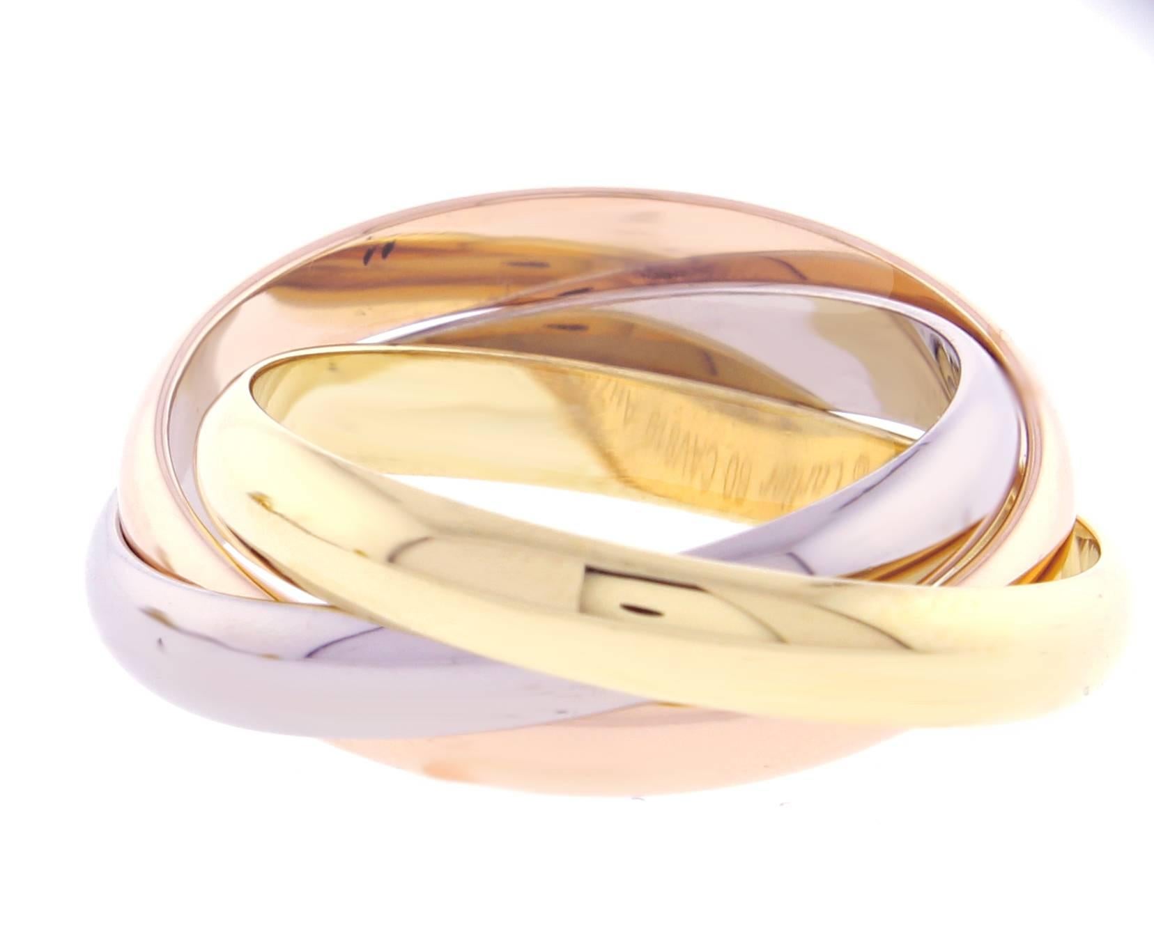 Three bands. Three colors. Pink gold, yellow gold and white gold, intertwined in a display of mystery and harmony.Cartier's timeless trinity ring.  Size 60 US 9 3.2mm wide bands
Original boxes certificate of authenticity
