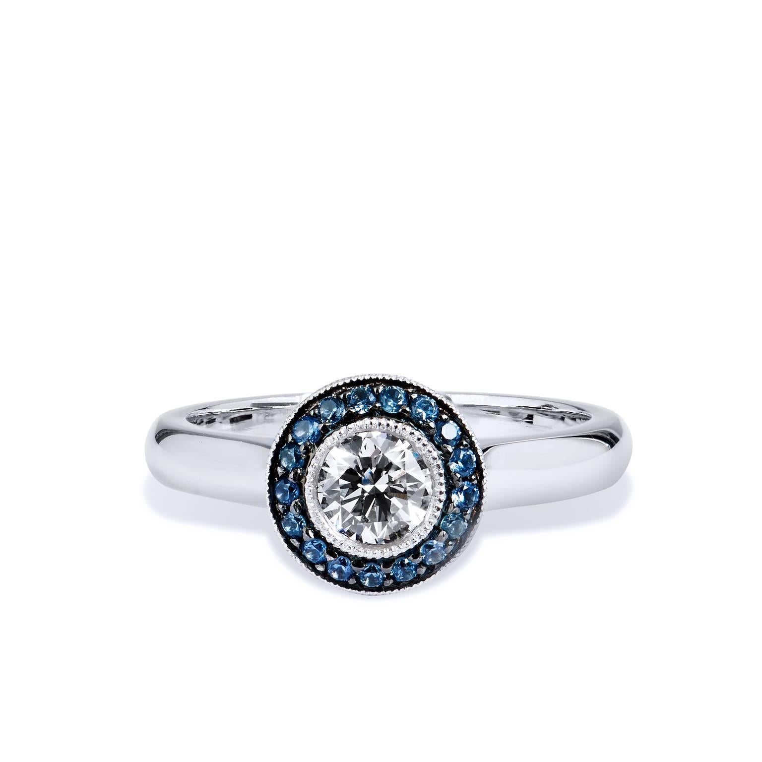 Handcrafted in 18kt white, this ring features a .51ct GIA certified center diamonds graded G SI1. Encompassing the center diamond are 17 pieces of light blue pave set sapphire that weigh .15ct total. This is a one-of-a-kind, original H&H design.