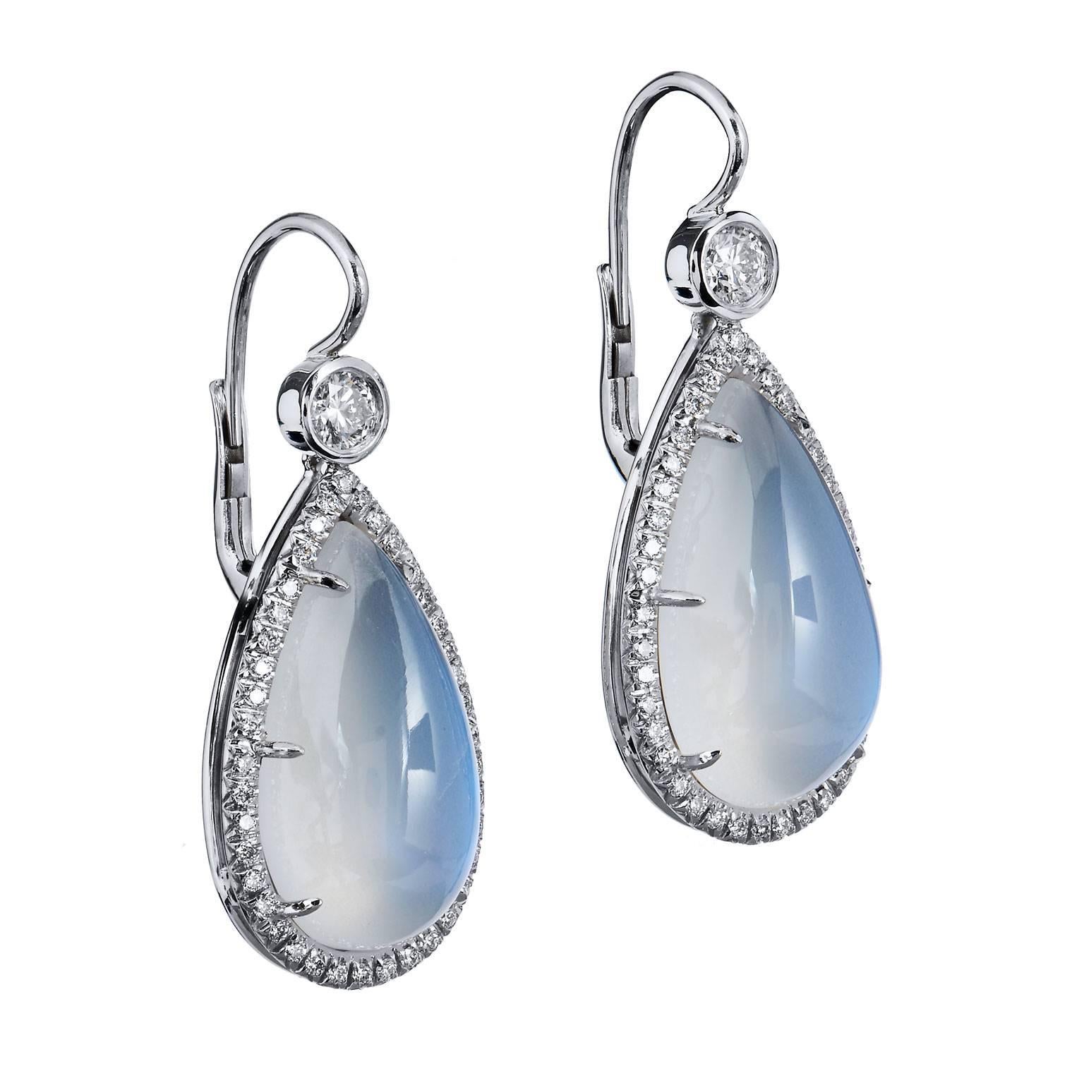 Mysterious  19 x 10 x 7 MM Earring  with Moonstones weighing 18.02 Carats in opaque Hues of blue and white, set in eighteen karat white gold surrounded by eighty two diamonds weighing .73 carats. French clips will hold the earring comfortably on