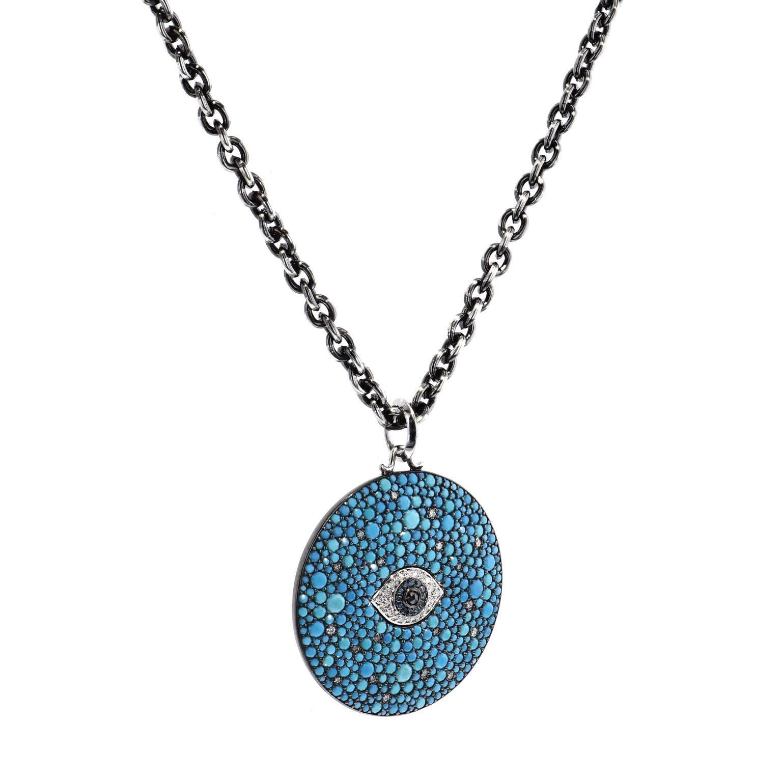 6.15 carat of crushed turquoise sets the base for this diamond evil eye pendant necklace strung on 32 inch silver chain. The evil eye is composed of 0.33 carat of white diamonds, 0.06 carat of blue diamond and 0.05 carat of black diamond set at