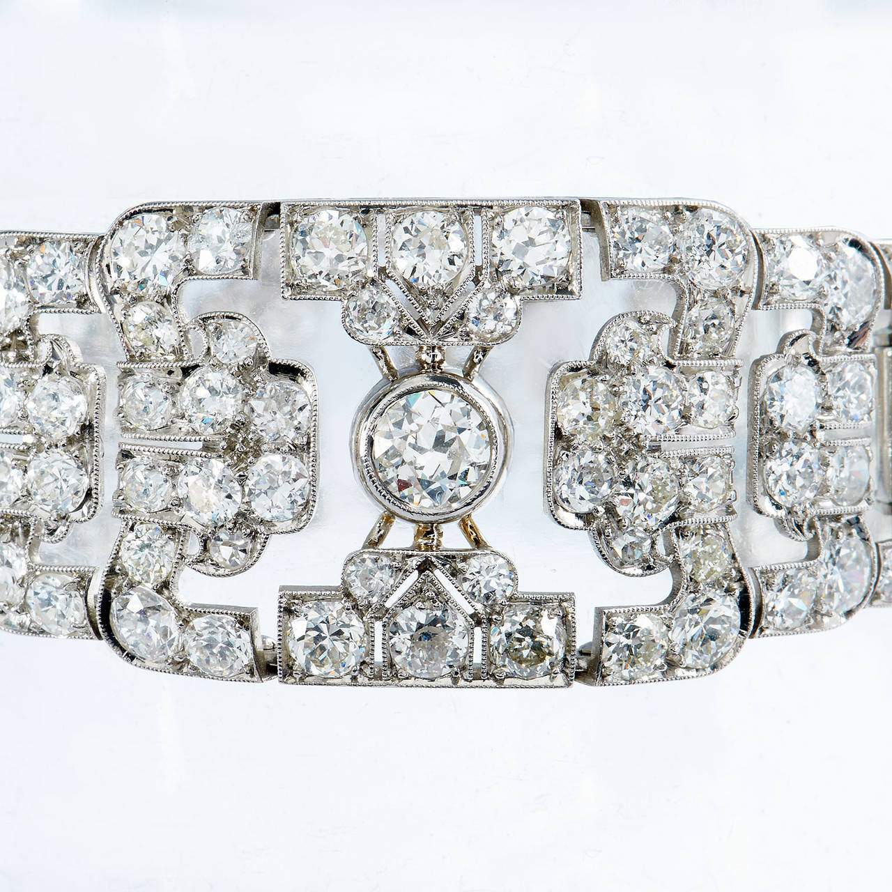This Art Deco three panel platinum bracelet consists of 220 old European cut diamonds with an impressive estimated total carat weight of 19.24. Prominently displayed in the center, sits a magnificent old European cut diamond that weighs 1.64 carats