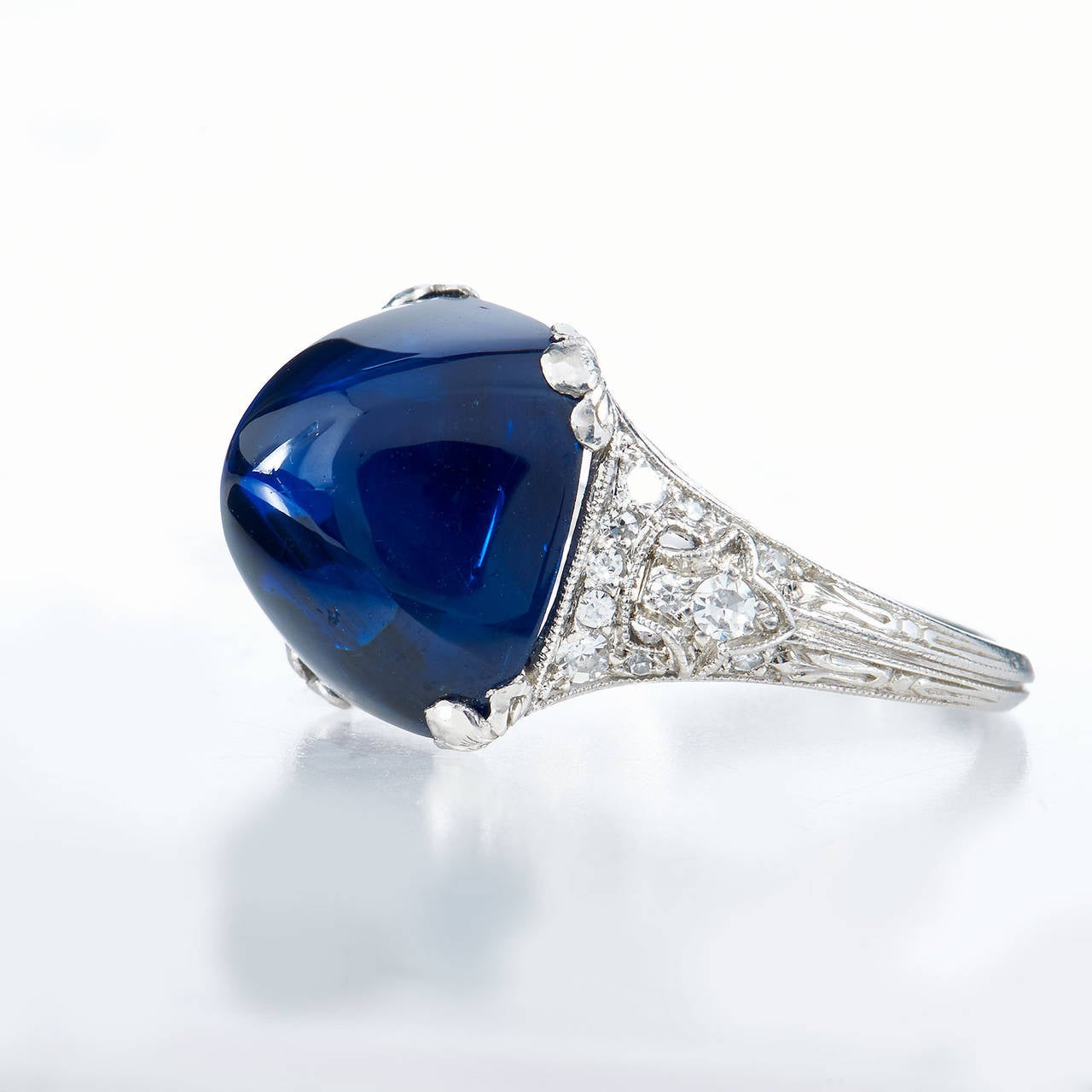 This classic Art Deco ring features a mesmerizing 11.92 carat sugarloaf single cabochon-cut blue sapphire with an AGL certificate stating the sapphire is Cambodian with no heat treatment. The cabochon-cut is a treasured cut that enhances the true