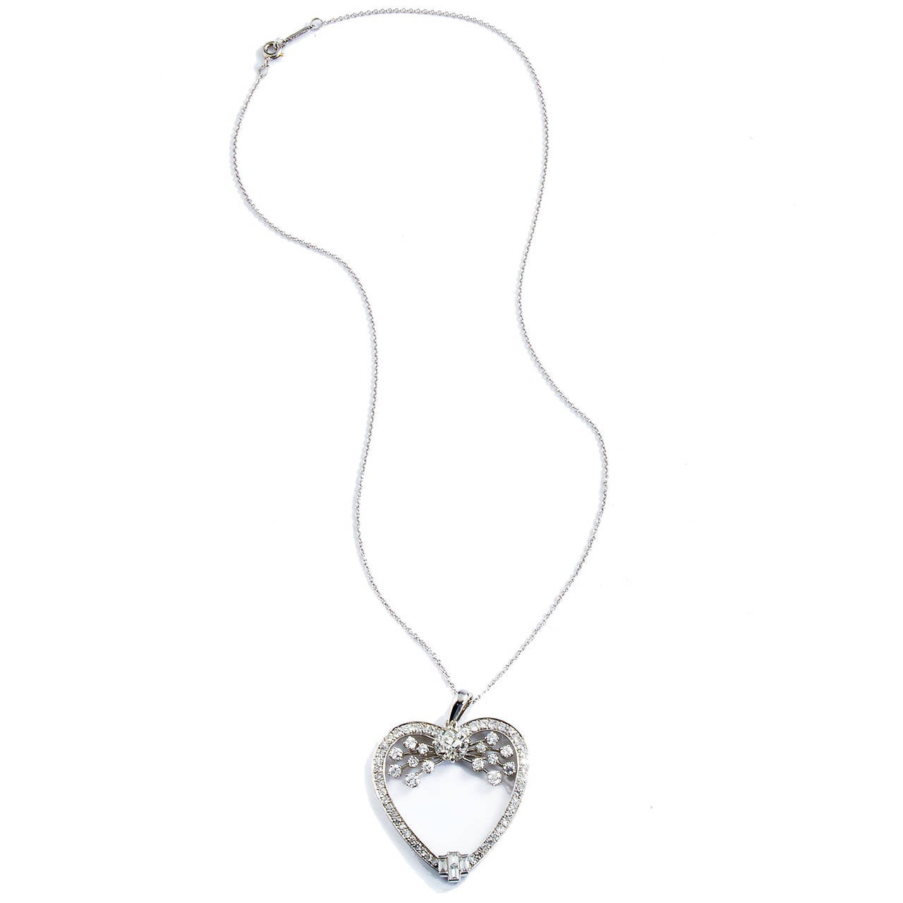 This sophisticated and feminine heart pendant is rendered in platinum with 64 brilliant, white, round diamonds weighing approximately 2.75 carats emanating pure radiance from it's frame. Evoking the movement of water, the 1.33 carat old European