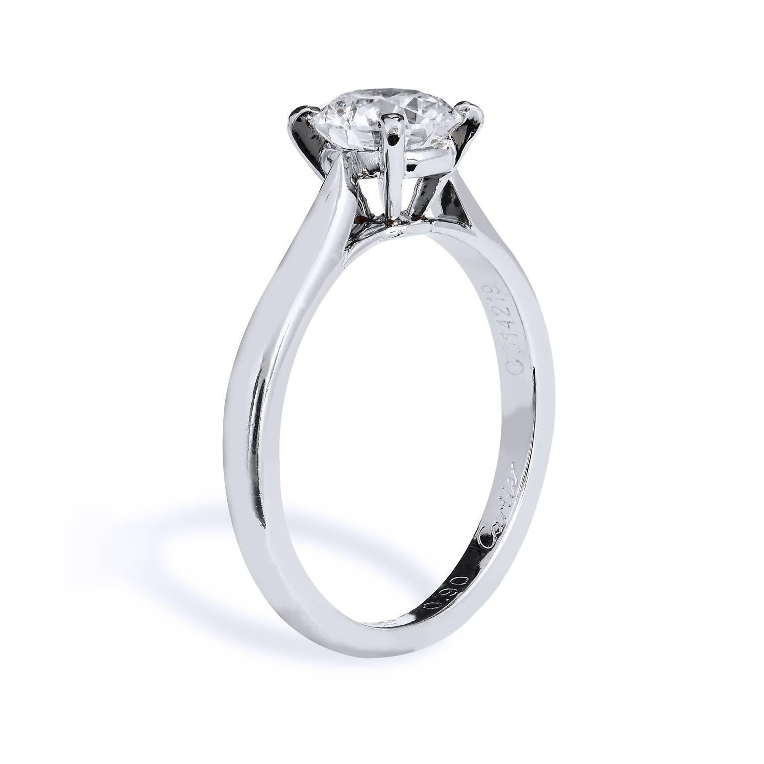 This platinum Cartier engagement ring features a simple and elegant solitaire design allowing the full beauty of the diamond to shine bright. The piece showcases a GIA certified .90ct F/VS2 round brilliant cut diamond and deemed authentic with a