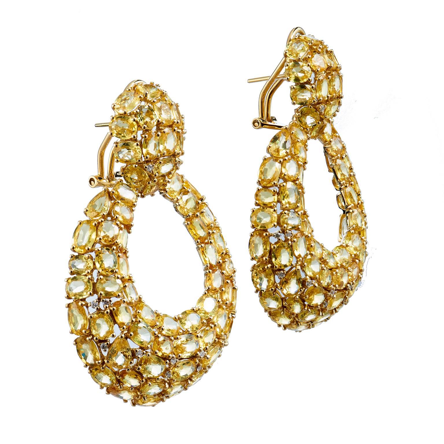 Glitz and glamour define this design. Crafted in 18kt yellow gold with diamonds, this pair of approximately 60-65ct yellow sapphire drop earrings are worthy of a red carpet moment and display iridescent sparkle in all lighting. A truly spectacular