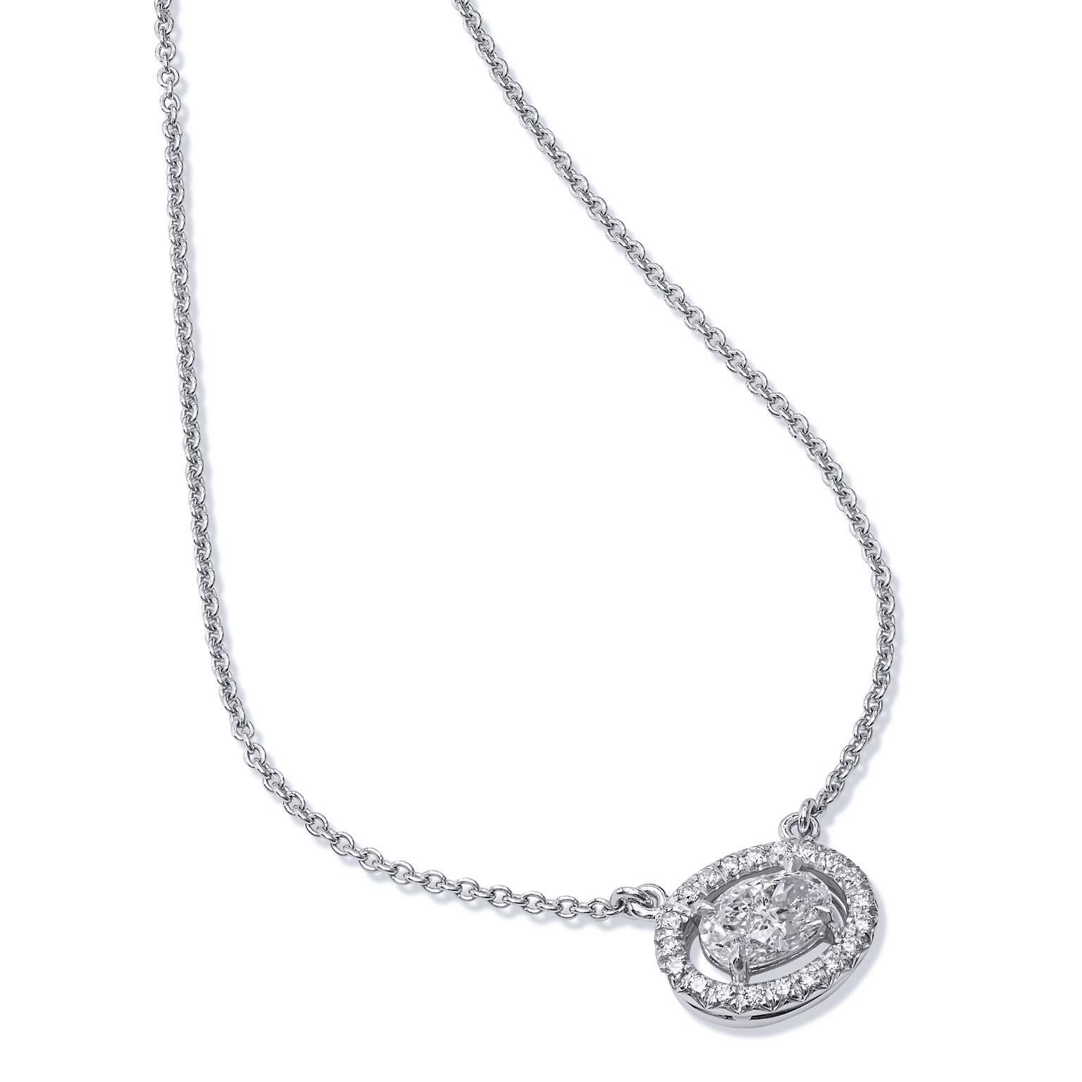 Crafted in 18kt white gold, this diamond pendant is classic design that can be worn with every day attire or dressed up for an evening out. The center oval diamond weighs .74cts and is graded G/H I2. Surrounding the oval diamond are 20 pave set