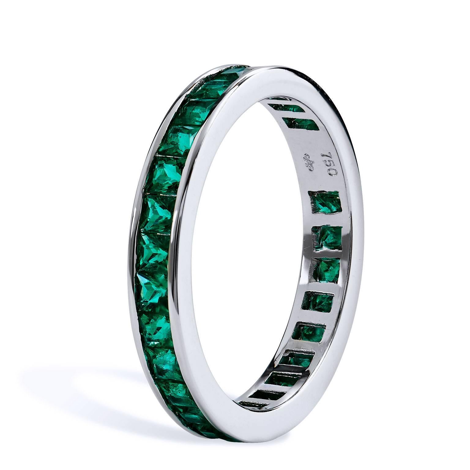 All around band contains twenty nine square emeralds. The band is crafted in eighteen karat white gold. A classic channel setting maximizes the bright emerald color of the 1.14 carats of emeralds 
The ring is a size 6
