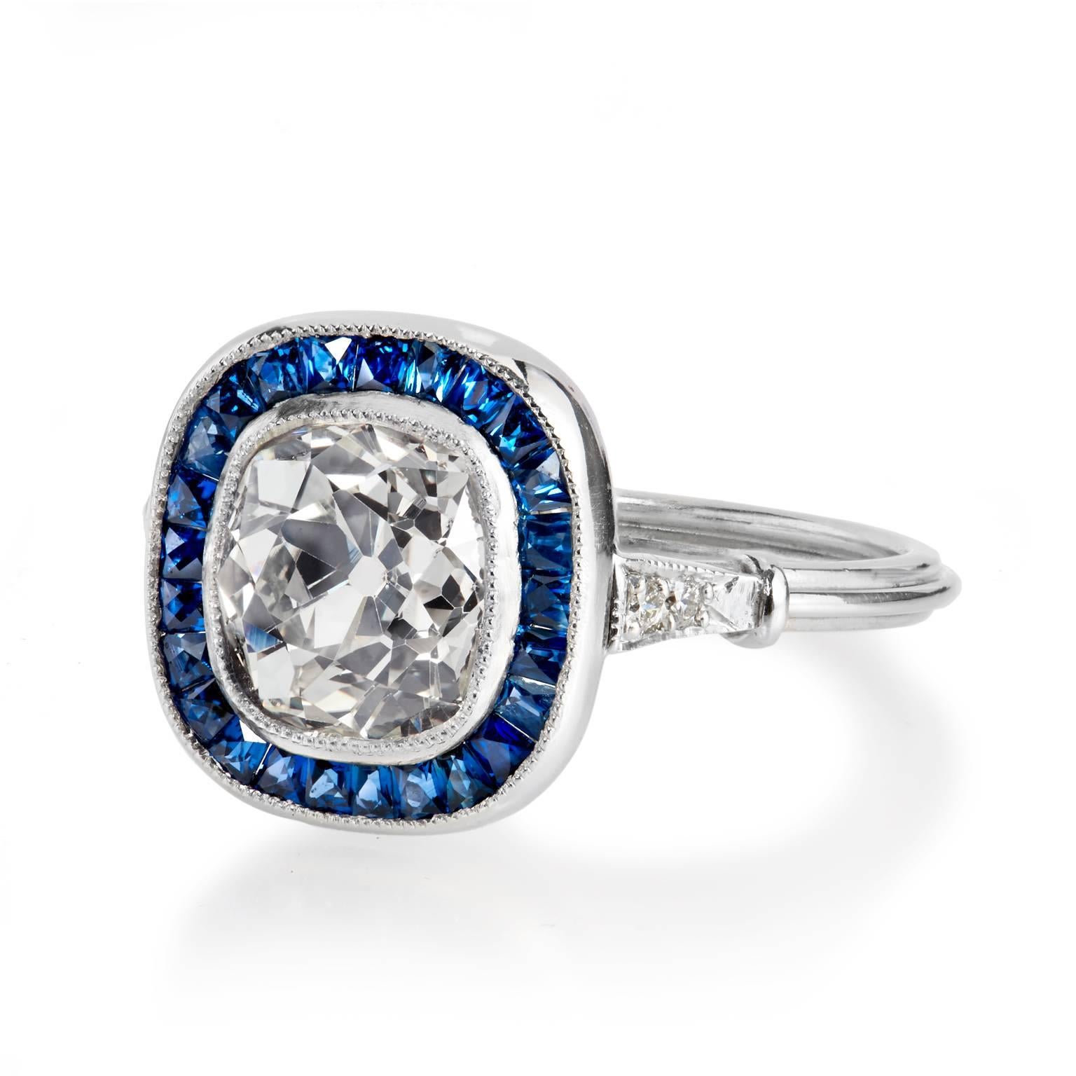 Art Deco Inspired Sapphire Diamond Gold Platinum Ring

This beautiful and nostalgic Art Deco inspired platinum ring captivates the eye with a bold 1.95 carat old mine cushion cut diamond (L/M/SI1) set at center. The geometry and symmetry of the