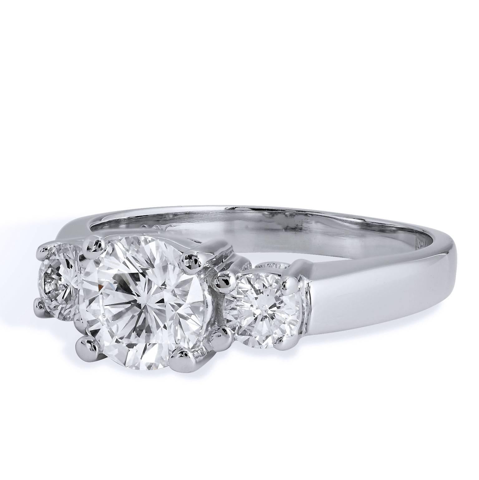 This chic and traditional platinum three stone diamond engagement ring features a 1.05 carat diamond at center stone (G/SI1/RBC; GIA # 14303888) while two pieces of 0.38 carats of diamond (G/H/SI2) are affixed at the shoulder. The tasteful front
