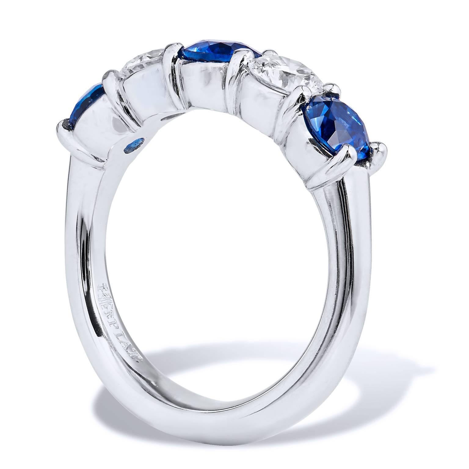 This platinum wedding band ring features three blue sapphires with a total weight of 1.48 carats. Interlaced between two Round Brilliant Cut diamonds (E/F/VS) in a shared prong style, with a total weight of 0.70 carat, this band ring stirs and
