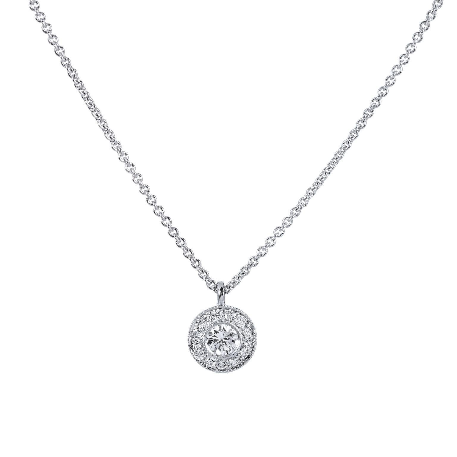 Fashioned in 18 karat white gold, this pendant features a 0.09 carat round brilliant cut diamond set at center (H/SI2) and embraced by 0.05 carat of pave set diamond on the perimeter (H/VS1). Make this necklace a staple jewelry piece in your