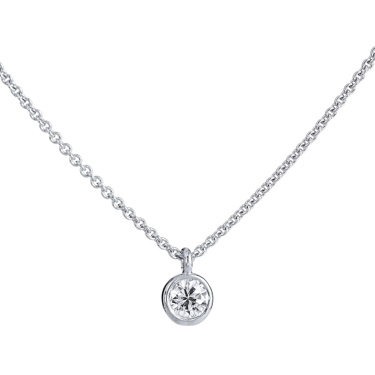 This H and H 18 karat white gold pendant features a lovely 0.11 carat round brilliant cut diamond at center bezel set (G/SI1). Simplicity and refinement reign supreme in this piece.