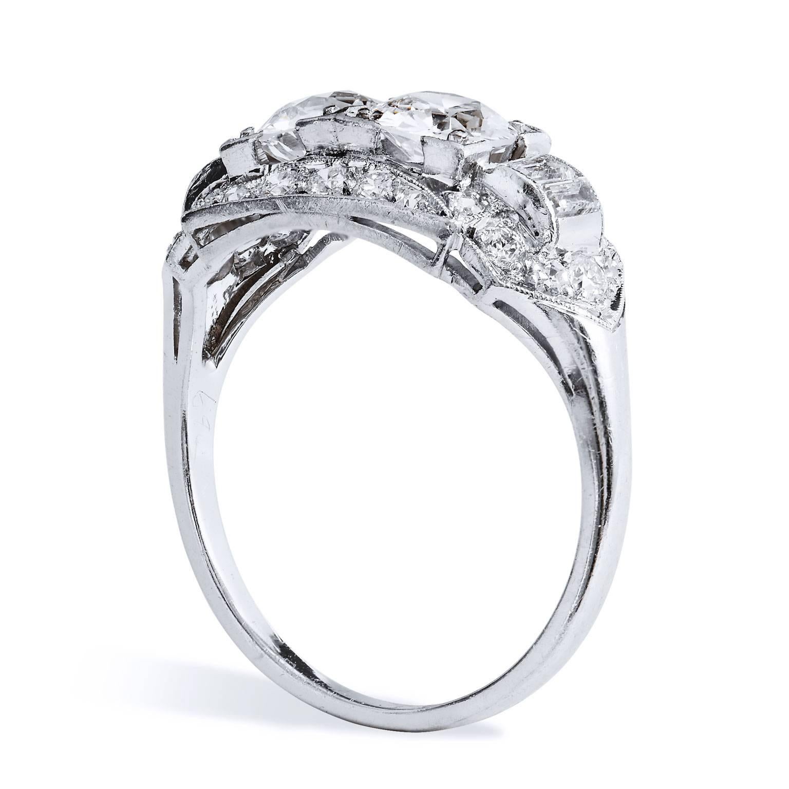 An engagement ring that stirs a sense revelry. This previously loved, ornate Art Deco platinum engagement ring features two Old European cut diamonds at center with a total weight of 1.10 carat (F/G/VS2). Four straight baguettes are prong set in a