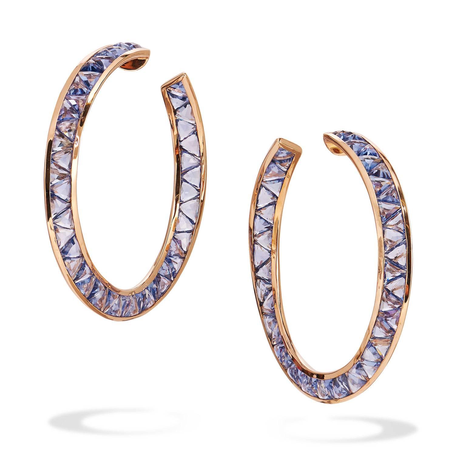 Enjoy these previously loved 18 karat rose gold hoops featuring ninety-two pieces of light blue/purple sapphires resulting in 22.10 carat in total weight. The earrings are 50 mm diameter.