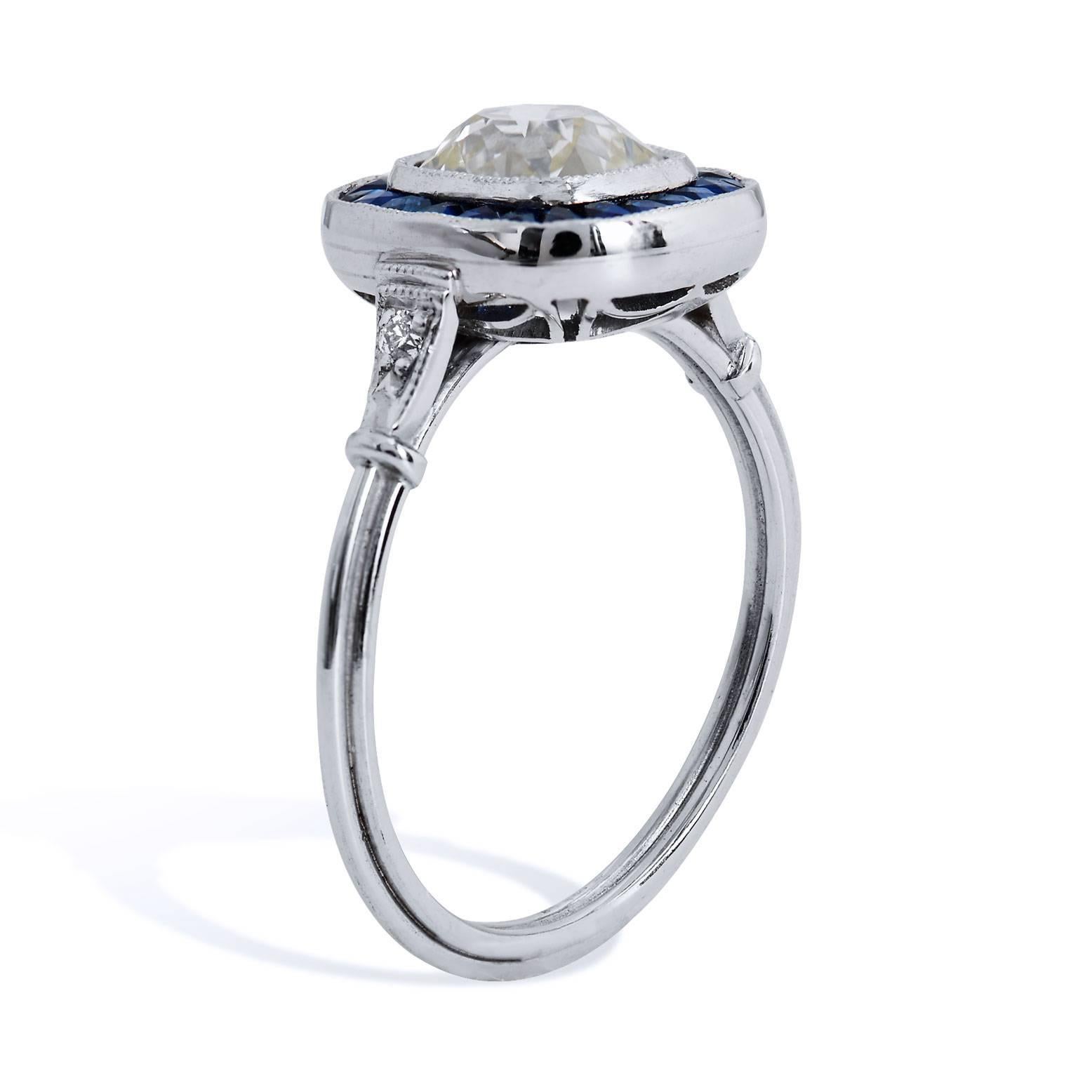 Crafted in platinum, this ring features a 1.44 carat N/O/VS2/SI1 graded Old Mine cut center diamond surrounded by 0.70 carat of french cut sapphires. The ring features a thin shank for a very soft and feminine feel that is set with 0.05 carat of