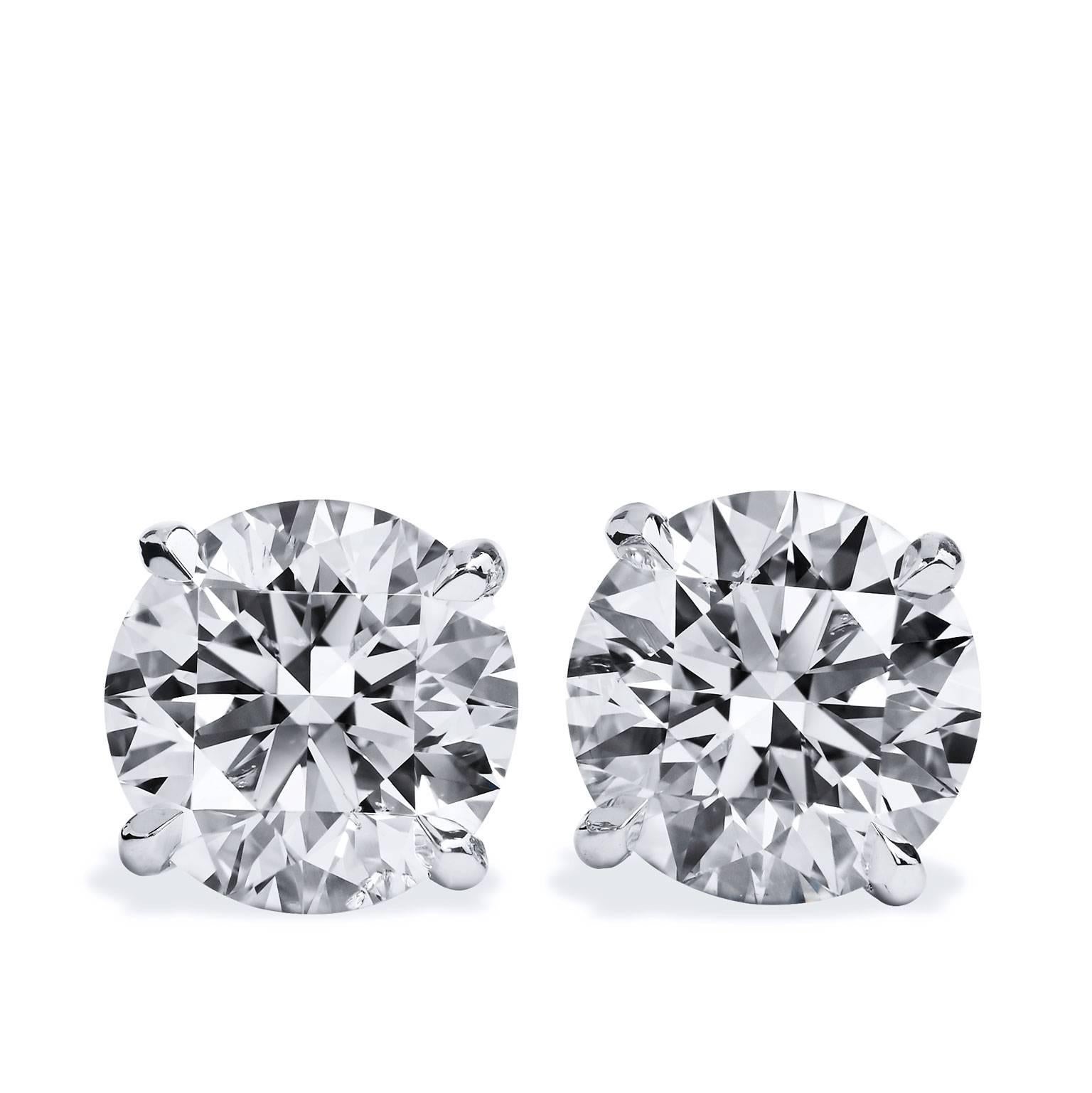 The perfect accessory to complete your sleek and stylish look. These handmade H and H 18 karat white gold round brilliant cut diamond stud earrings are just charming. Two diamonds with a total weight of 4.45 carat are four-prong set and are H in