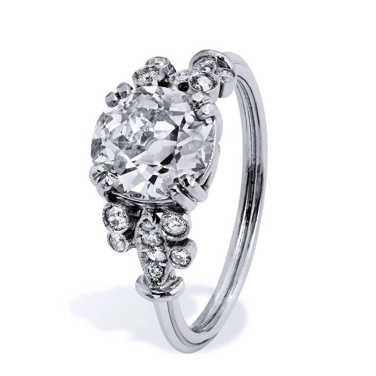 This previously loved engagement ring is a piece with a voice. This ornate platinum engagement ring is recreated in the classic Edwardian design and features a 1.88 carat Old European Cut diamond prong set at center (N/SI2; GIA#5172679673). A total