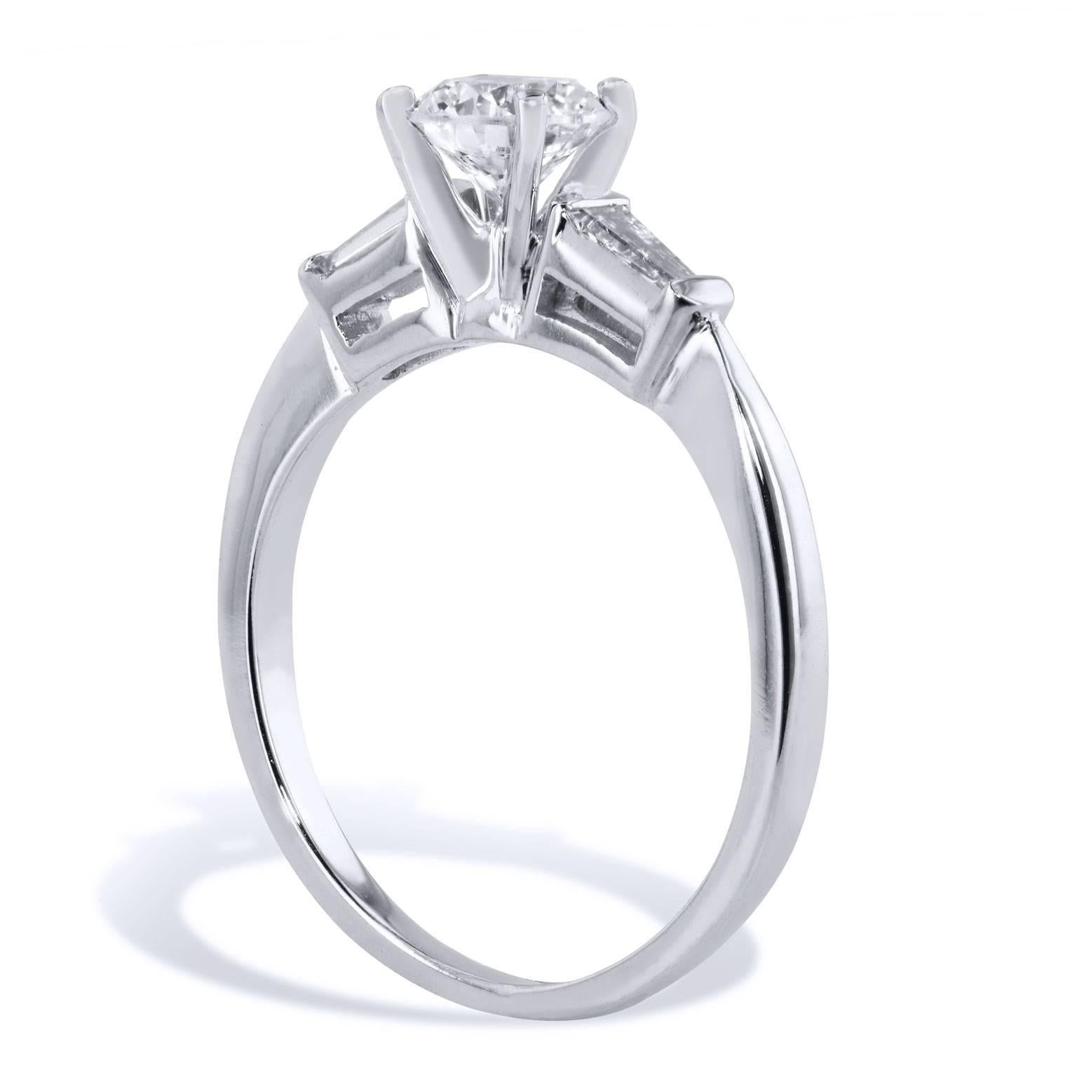 Leave her suspended in a dream with this beautiful H & H, handcrafted 14 karat white gold and diamond engagement ring. Two tapered baguette diamond side stones weighing a total of 0.20 carat (H/I/VS) draw the eye toward the lovely 0.64 carat diamond