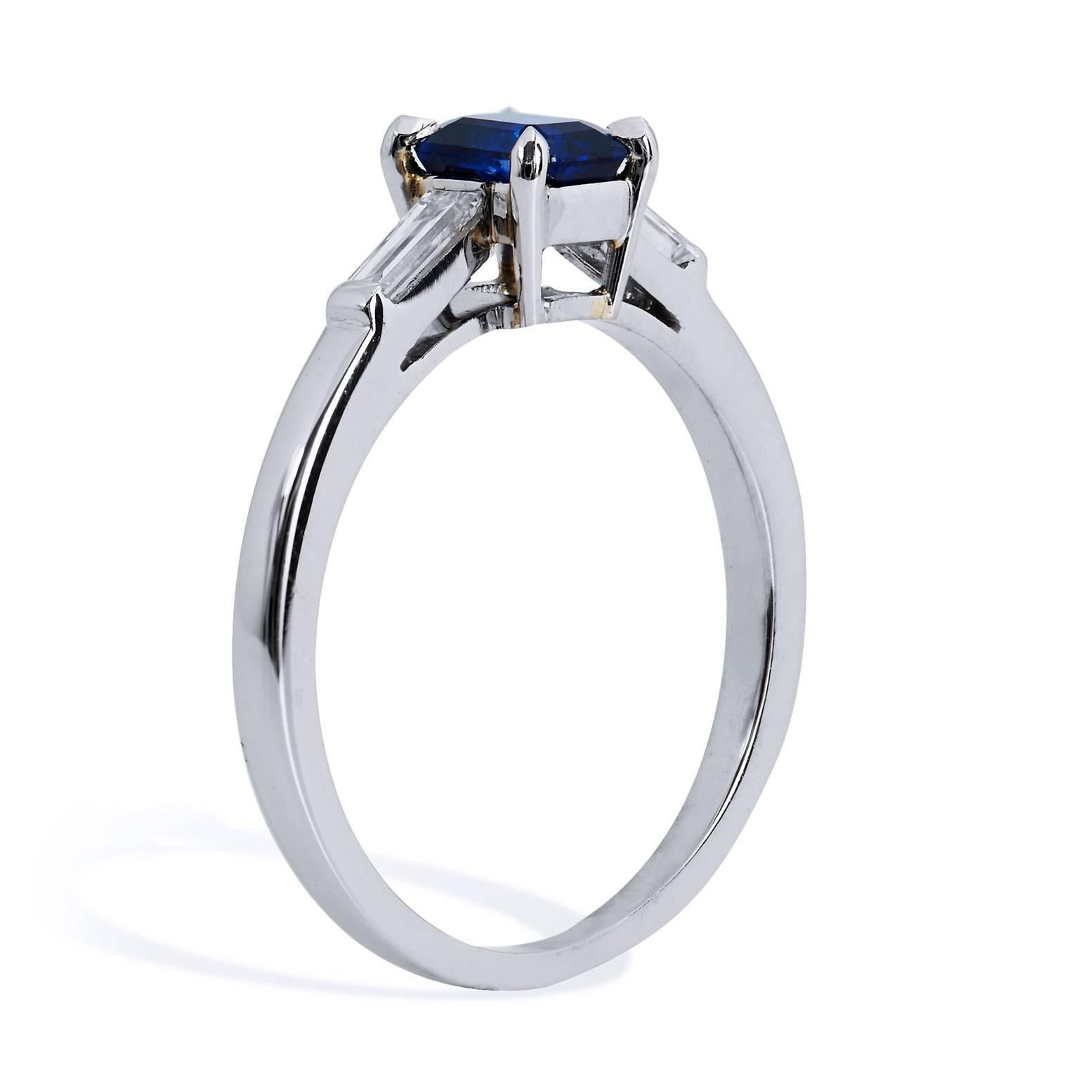 Bold, yet refined- a 0.73 carat emerald cut royal blue sapphire is set at center in this handmade platinum ring. Accompanied by two straight baguette cut diamonds, with a total weight of 0.18 carat (G/H/VS), on each side this ring is simplistic and