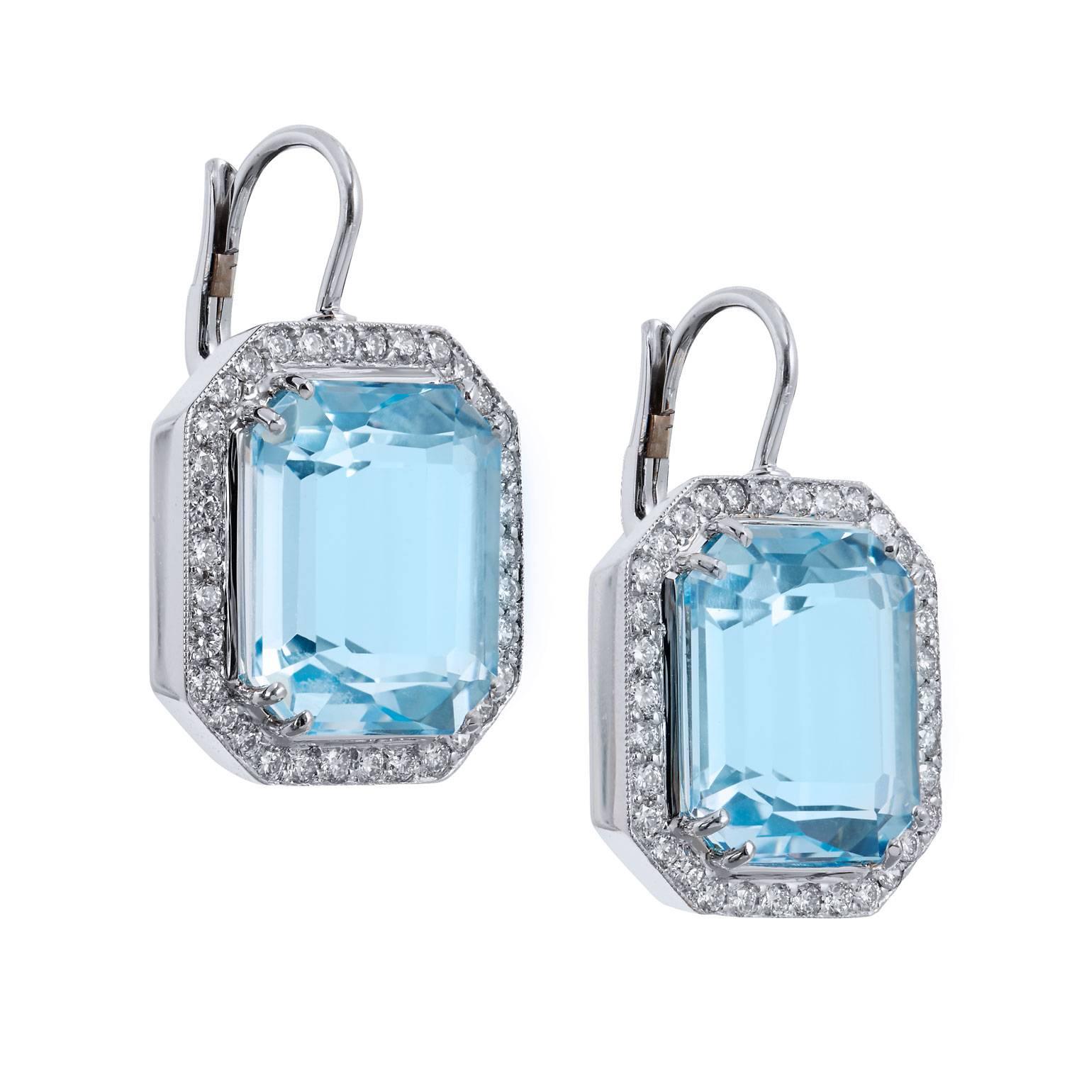 Enjoy a piece of simple elegance with these bezel set blue topaz and diamond pave lever-back earrings. Handcrafted in 18 karat white gold, these earrings feature 0.66 carat of pave set diamond (F/G/VS1) sweeping the bezel surrounding the 18.29 