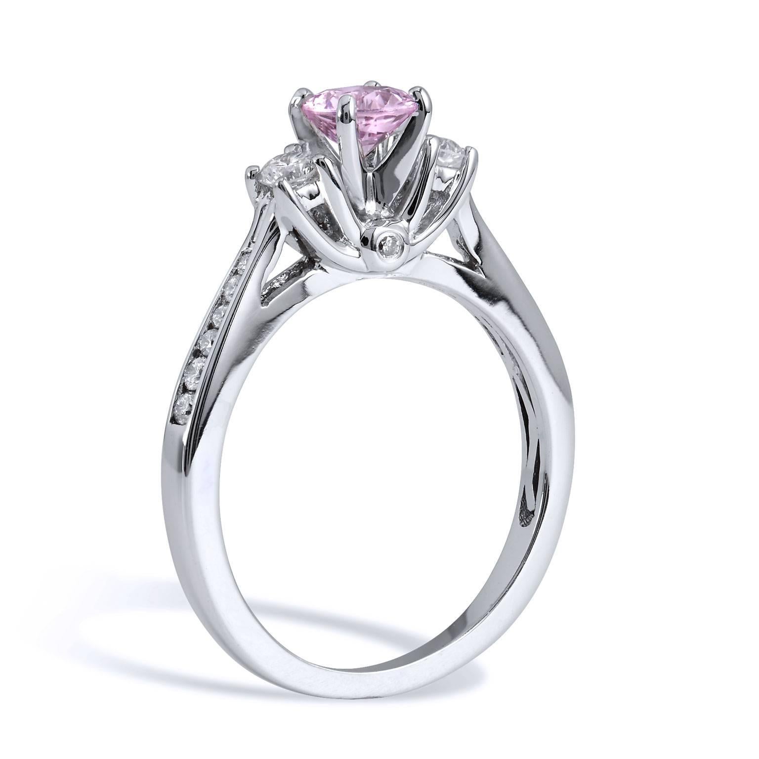 Enjoy this previously loved 0.55 carat round, no-heat pink sapphire set at center. Accompanied by two accent round diamonds, with a total weight of 0.15 carat affixed at each side, 0.08 carat of pave-set diamond sweep the shank with grace. For added